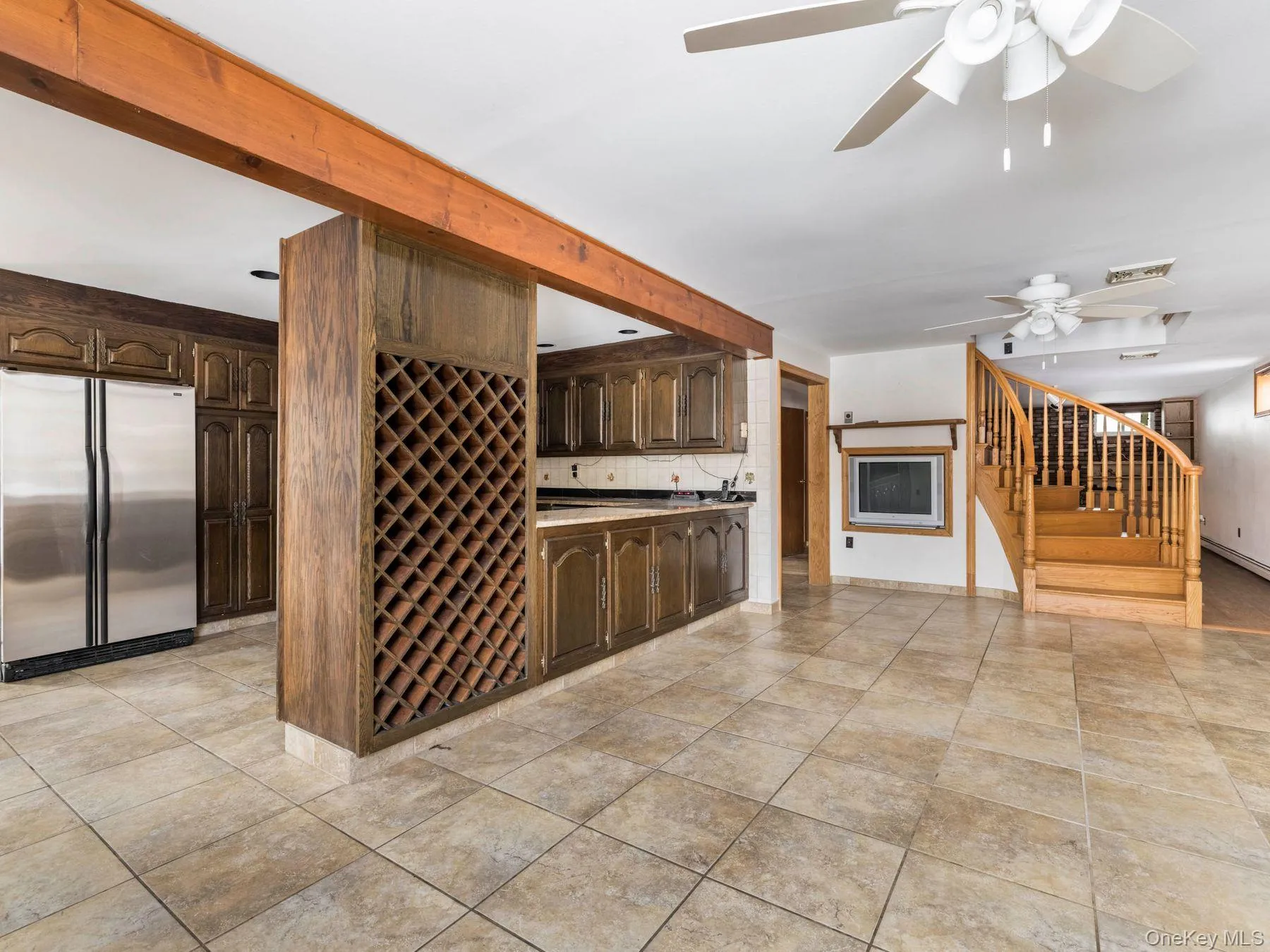 Kitchen with dark brown cabinetry, stainless steel fridge, light countertops, tasteful backsplash, and ceiling fan Kitchen with dark brown cabinetry, stainless steel fridge, light countertops, tasteful backsplash, and ceiling fan