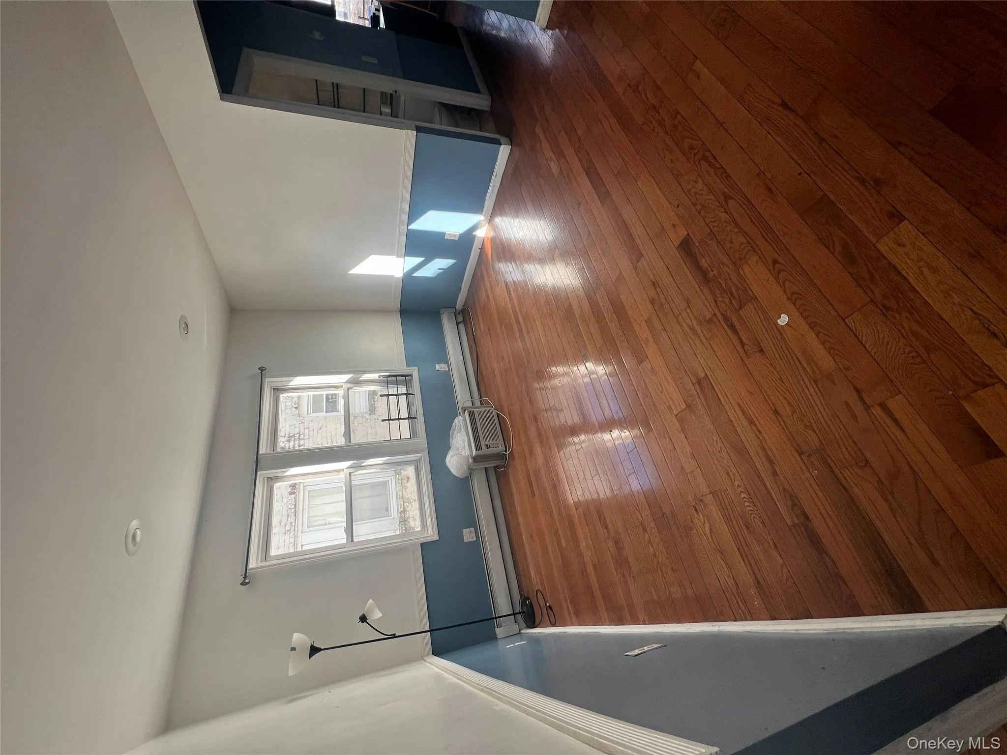 Empty room featuring dark wood finished floors and baseboard heating Empty room featuring dark wood finished floors and baseboard heating