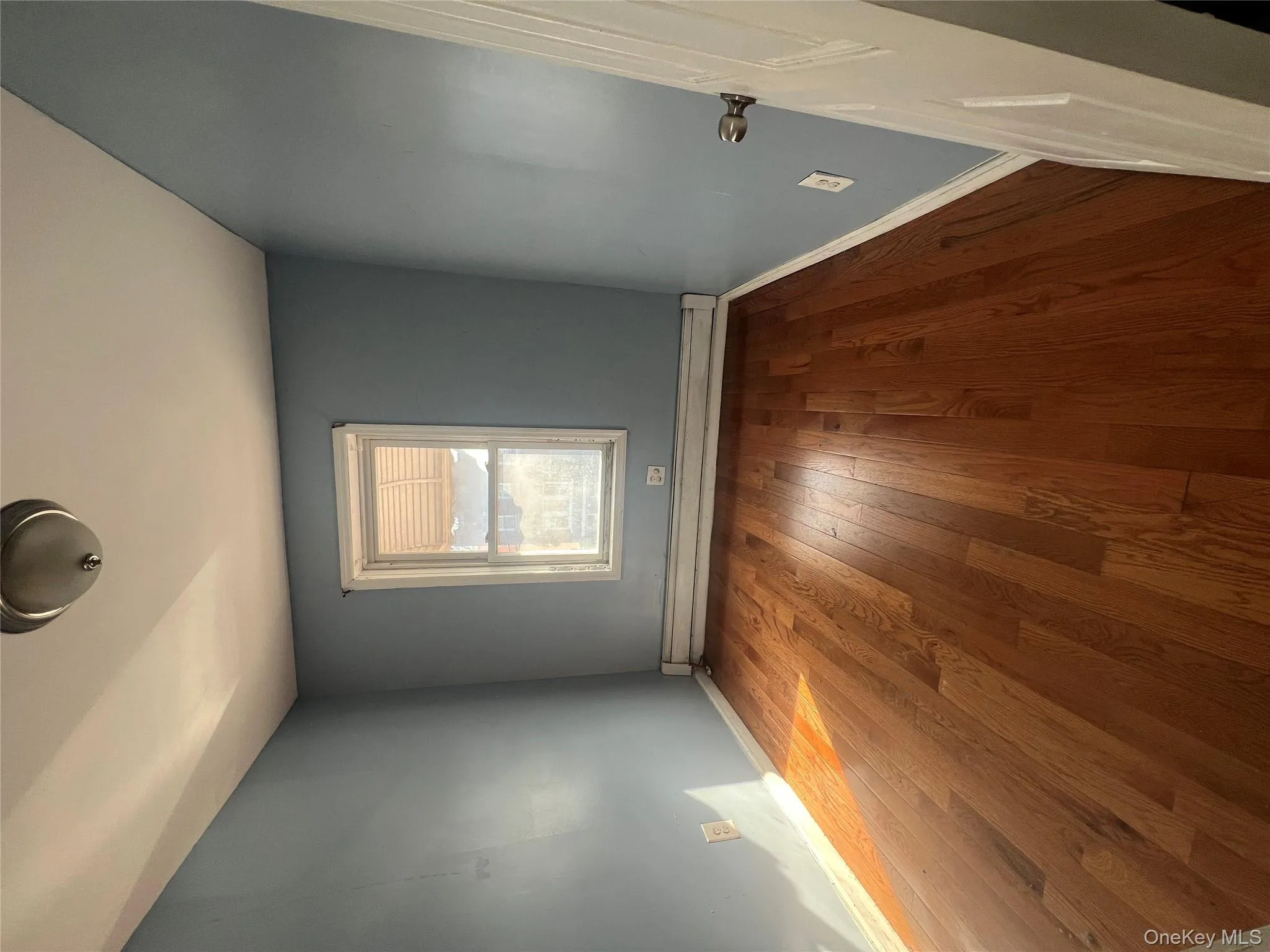 Empty room featuring baseboard heating and hardwood / wood-style flooring Empty room featuring baseboard heating and hardwood / wood-style flooring