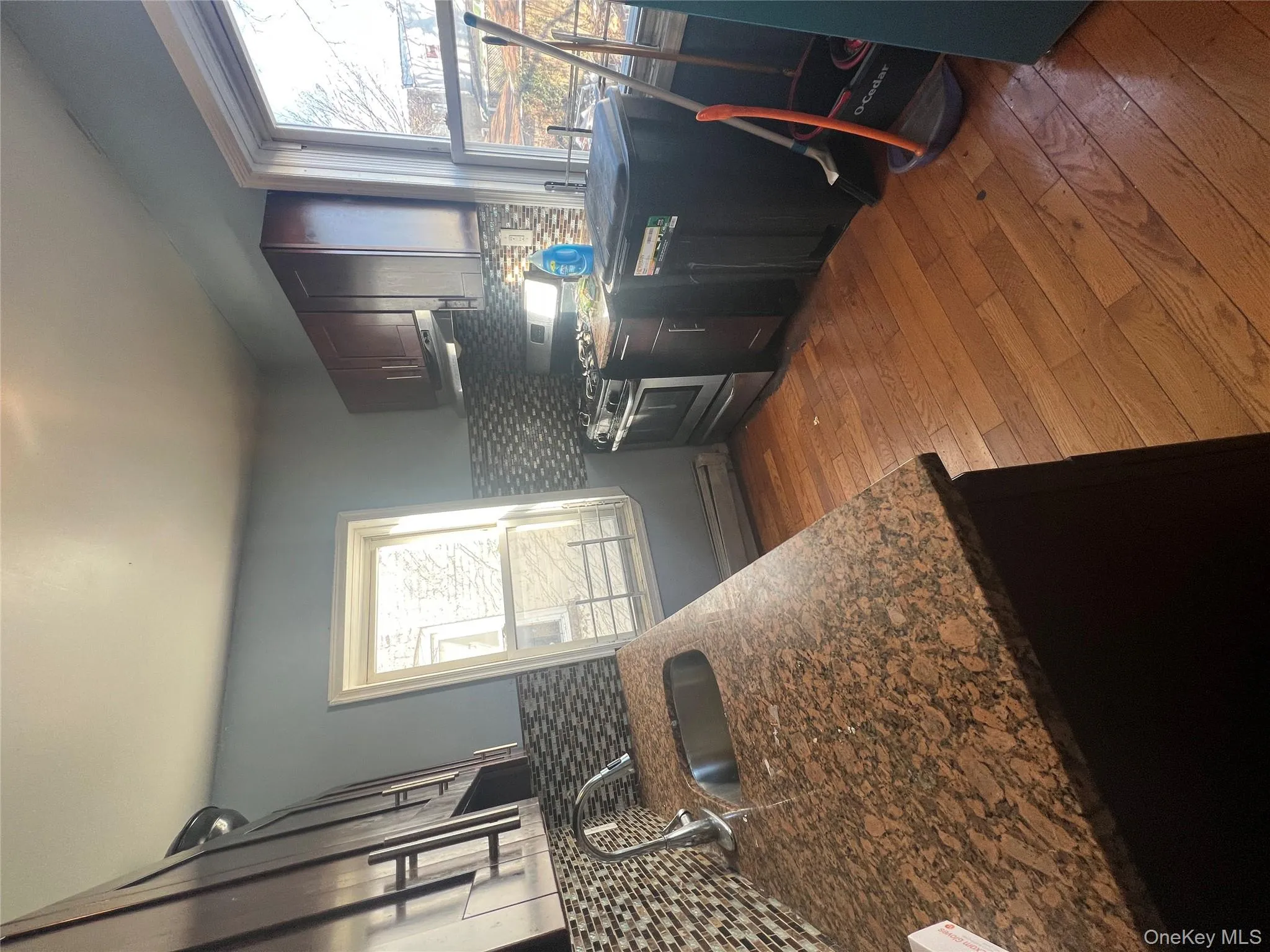 Kitchen featuring range, dark wood finished floors, dark stone counters, decorative backsplash, and range hood Kitchen featuring range, dark wood finished floors, dark stone counters, decorative backsplash, and range hood