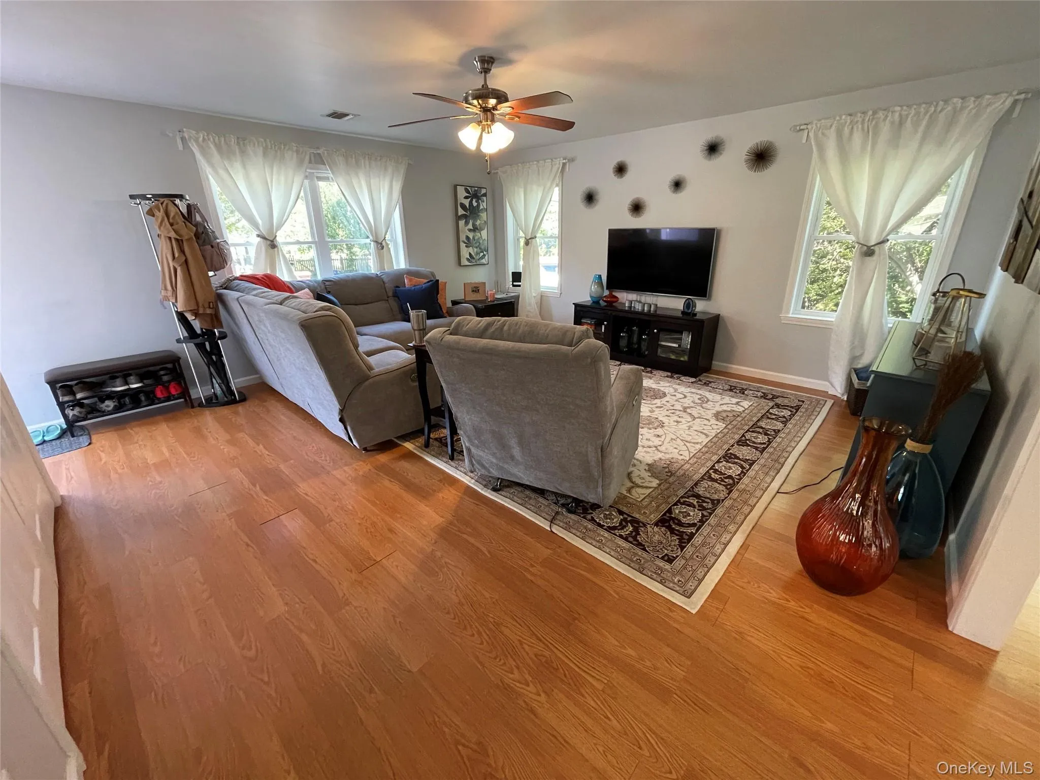 Living area with laminate wood-type flooring and a ceiling fan Living area with laminate wood-type flooring and a ceiling fan