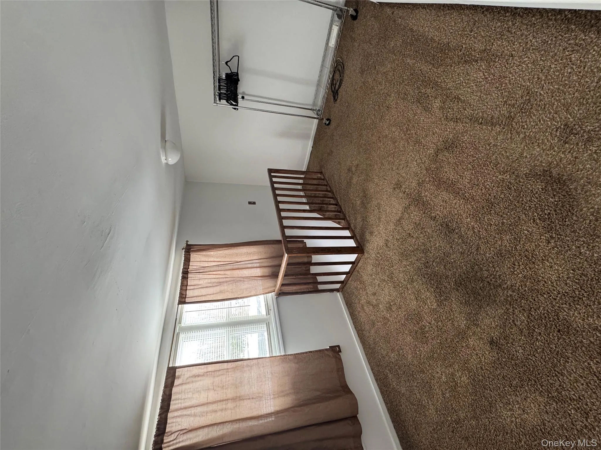 Unfurnished room with carpet flooring and baseboards Unfurnished room with carpet flooring and baseboards