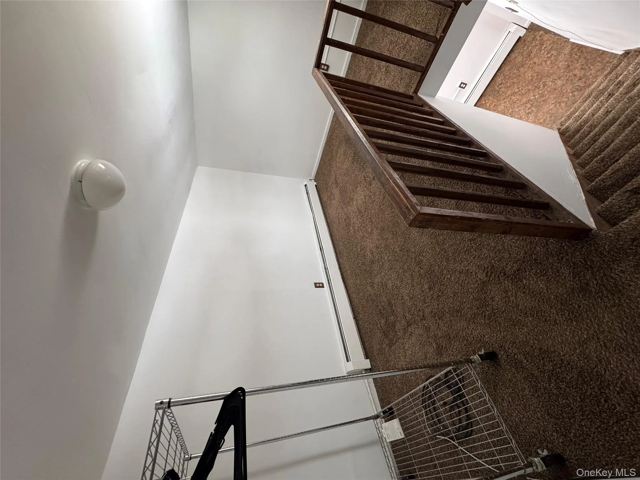 Staircase featuring carpet floors and a baseboard heating unit Staircase featuring carpet floors and a baseboard heating unit