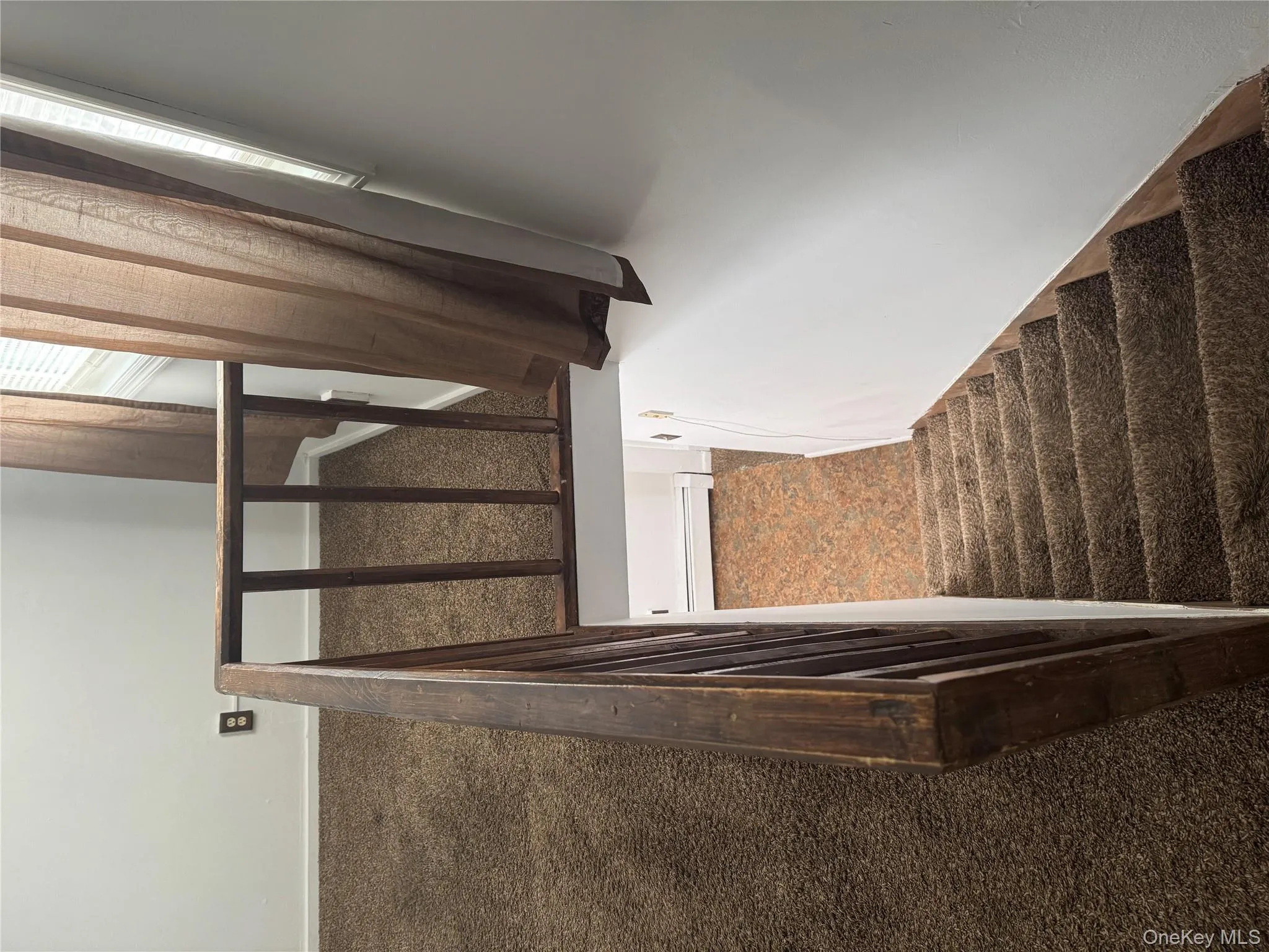 Stairway with carpet flooring and baseboard heating Stairway with carpet flooring and baseboard heating