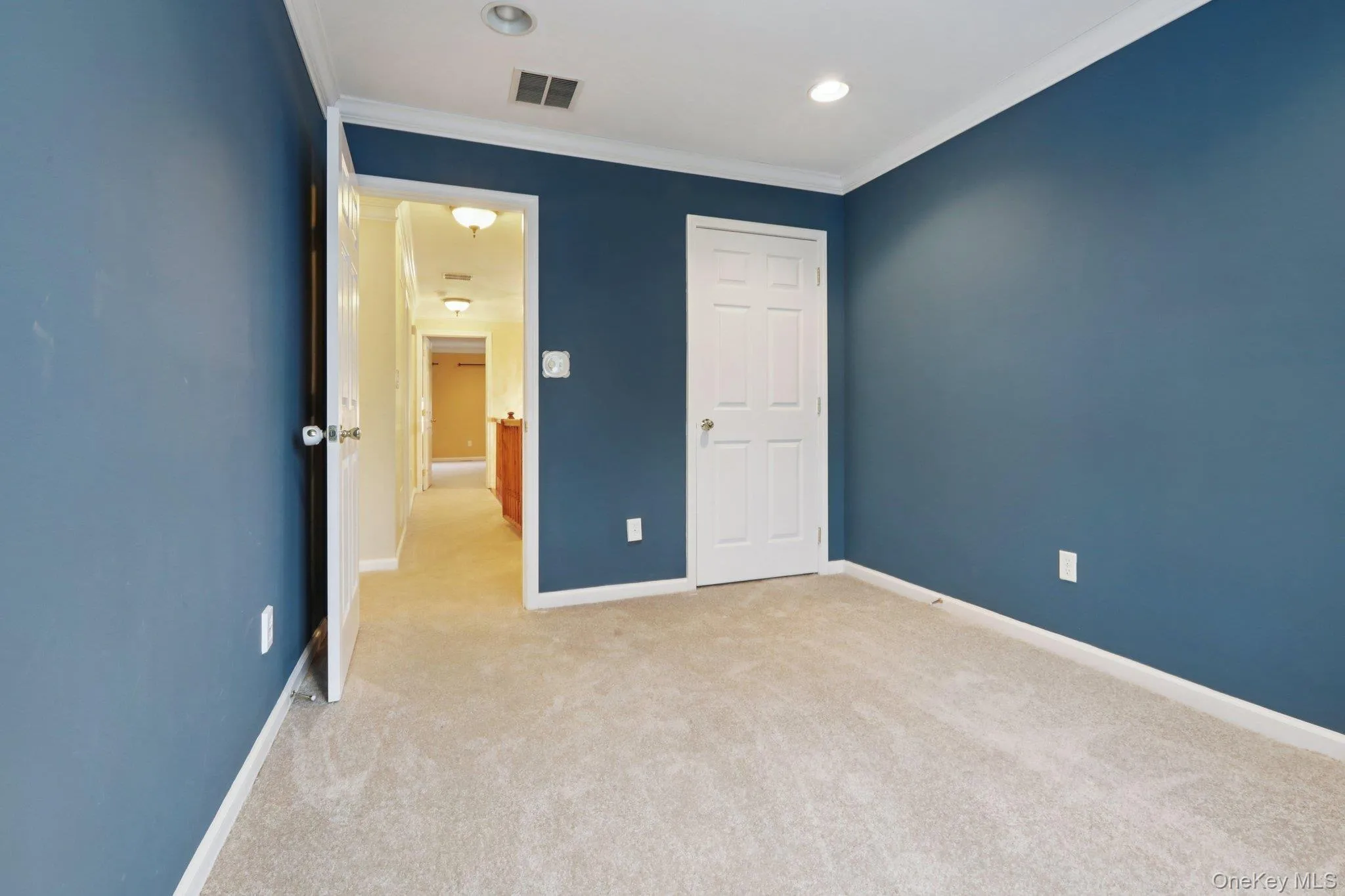 Unfurnished bedroom featuring light colored carpet, crown molding, and recessed lighting Unfurnished bedroom featuring light colored carpet, crown molding, and recessed lighting