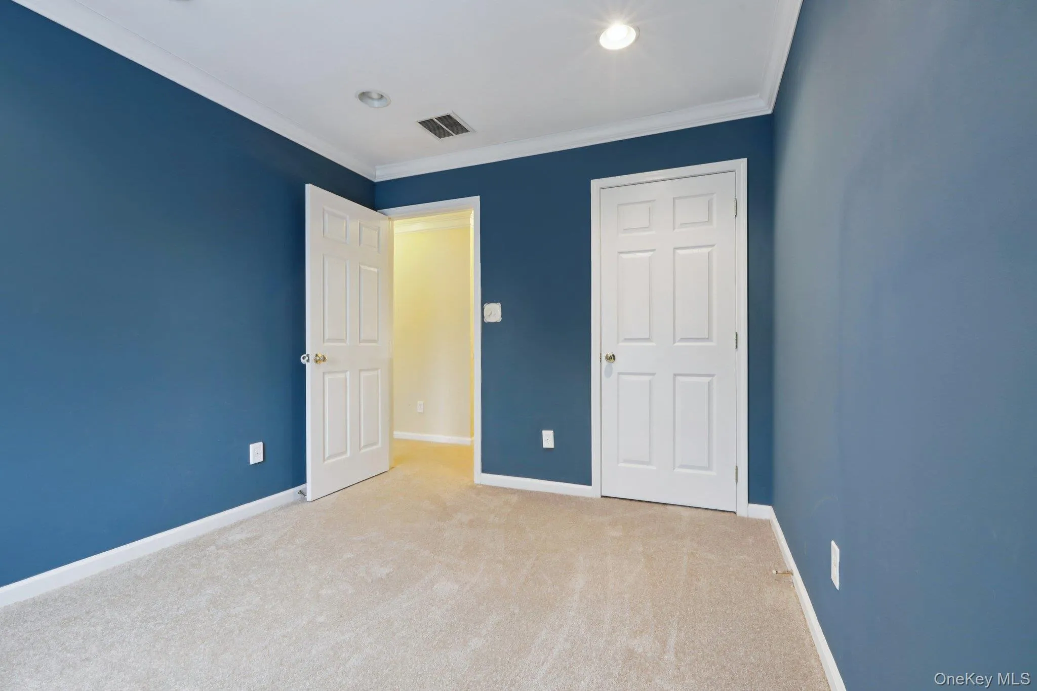 Unfurnished bedroom with carpet flooring, crown molding, and recessed lighting Unfurnished bedroom with carpet flooring, crown molding, and recessed lighting