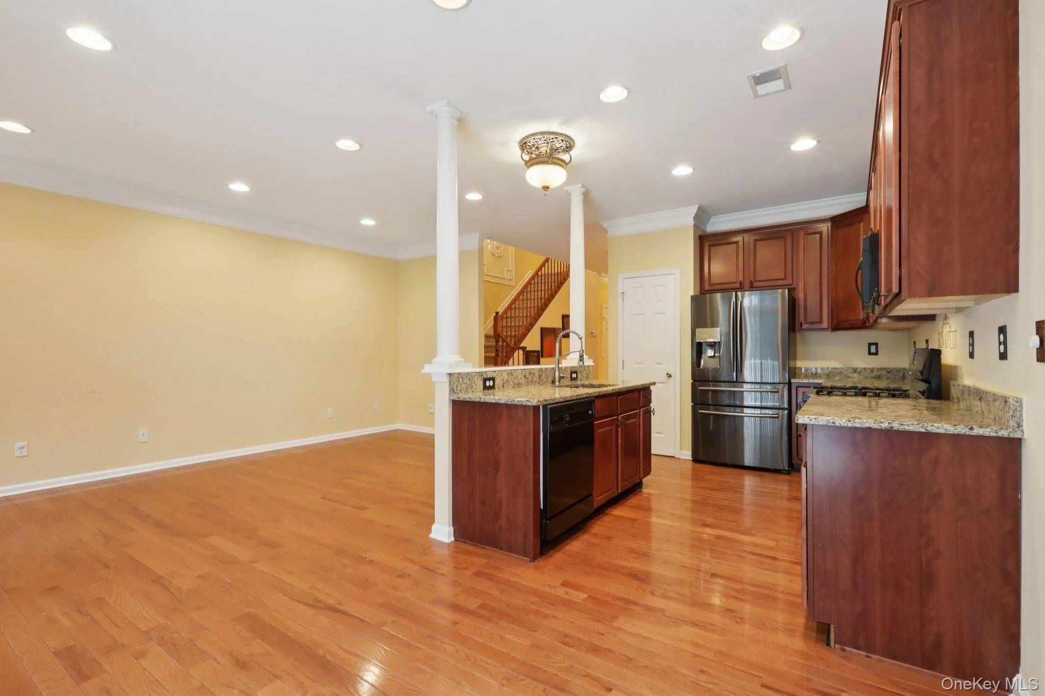 Kitchen featuring light stone counters, black appliances, recessed lighting, light wood-style floors, and open floor plan Kitchen featuring light stone counters, black appliances, recessed lighting, light wood-style floors, and open floor plan