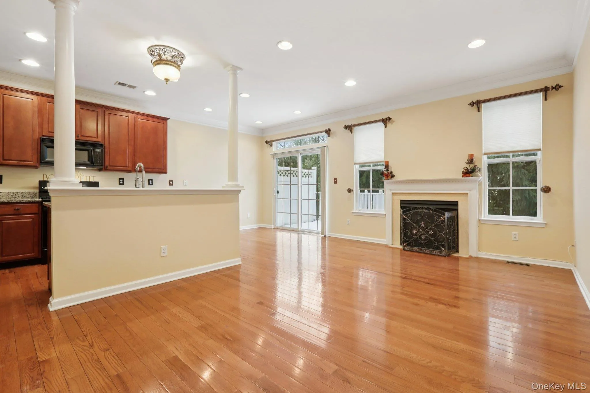 Kitchen with crown molding, open floor plan, recessed lighting, light hardwood flooring, and a fireplace Kitchen with crown molding, open floor plan, recessed lighting, light hardwood flooring, and a fireplace