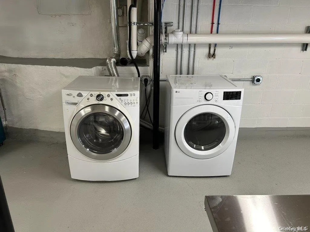 Laundry area with washing machine and clothes dryer and finished concrete flooring Laundry area with washing machine and clothes dryer and finished concrete flooring