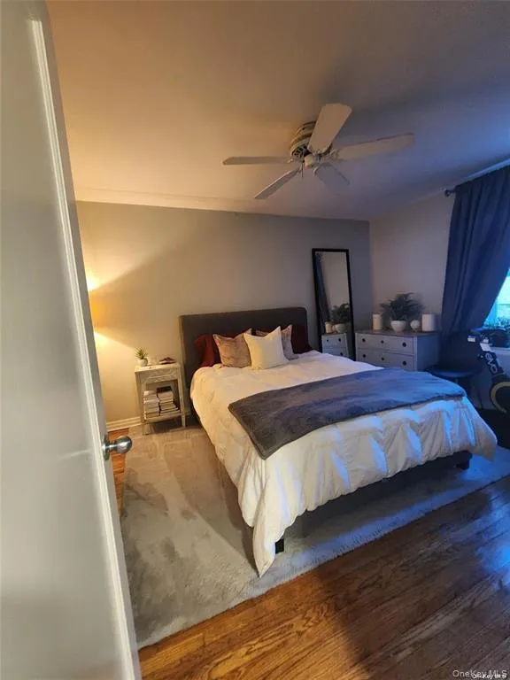 Bedroom featuring a ceiling fan and hardwood / wood-style flooring Bedroom featuring a ceiling fan and hardwood / wood-style flooring