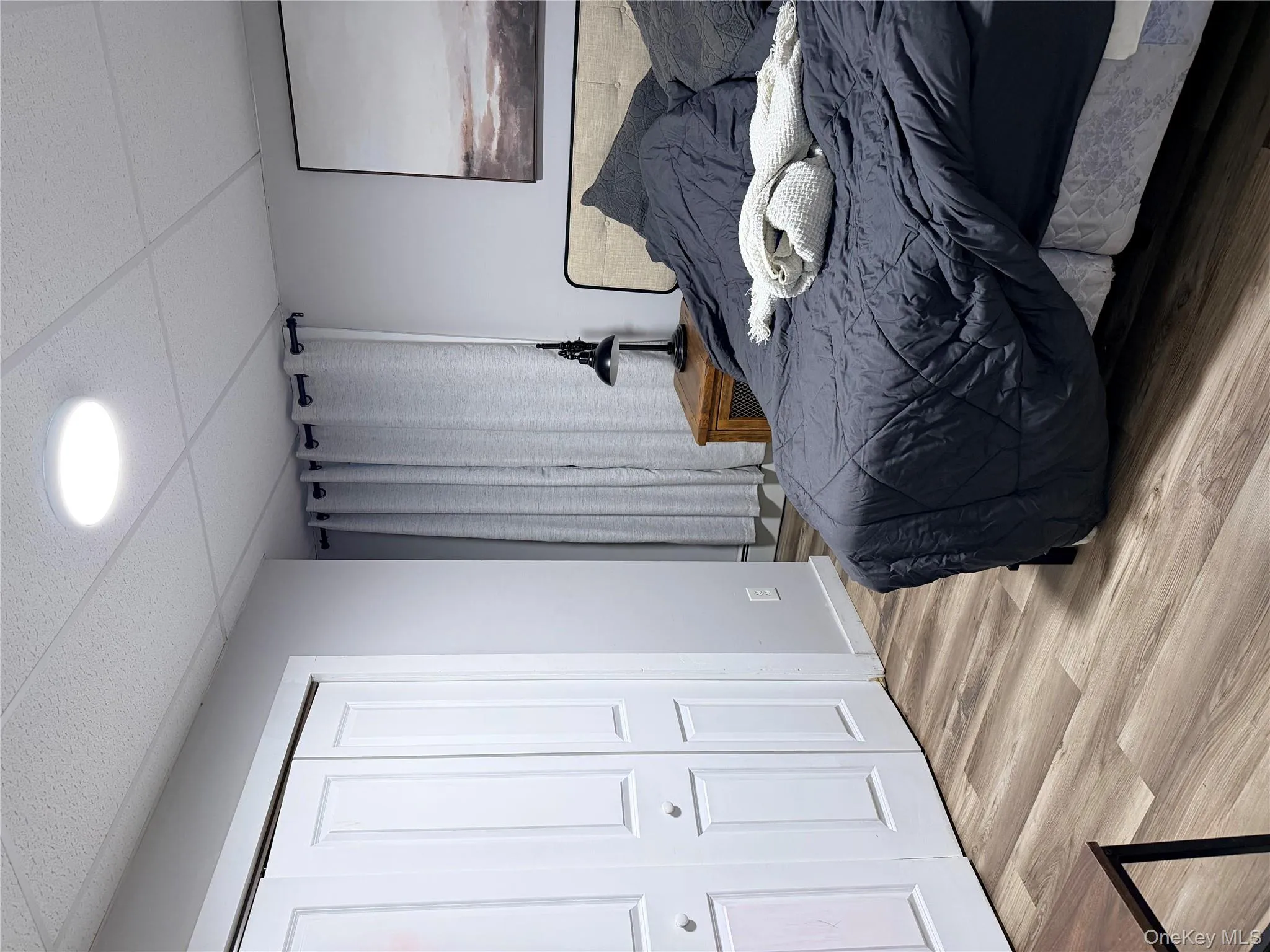 Bedroom featuring a drop ceiling, wood finished floors, and a closet Bedroom featuring a drop ceiling, wood finished floors, and a closet