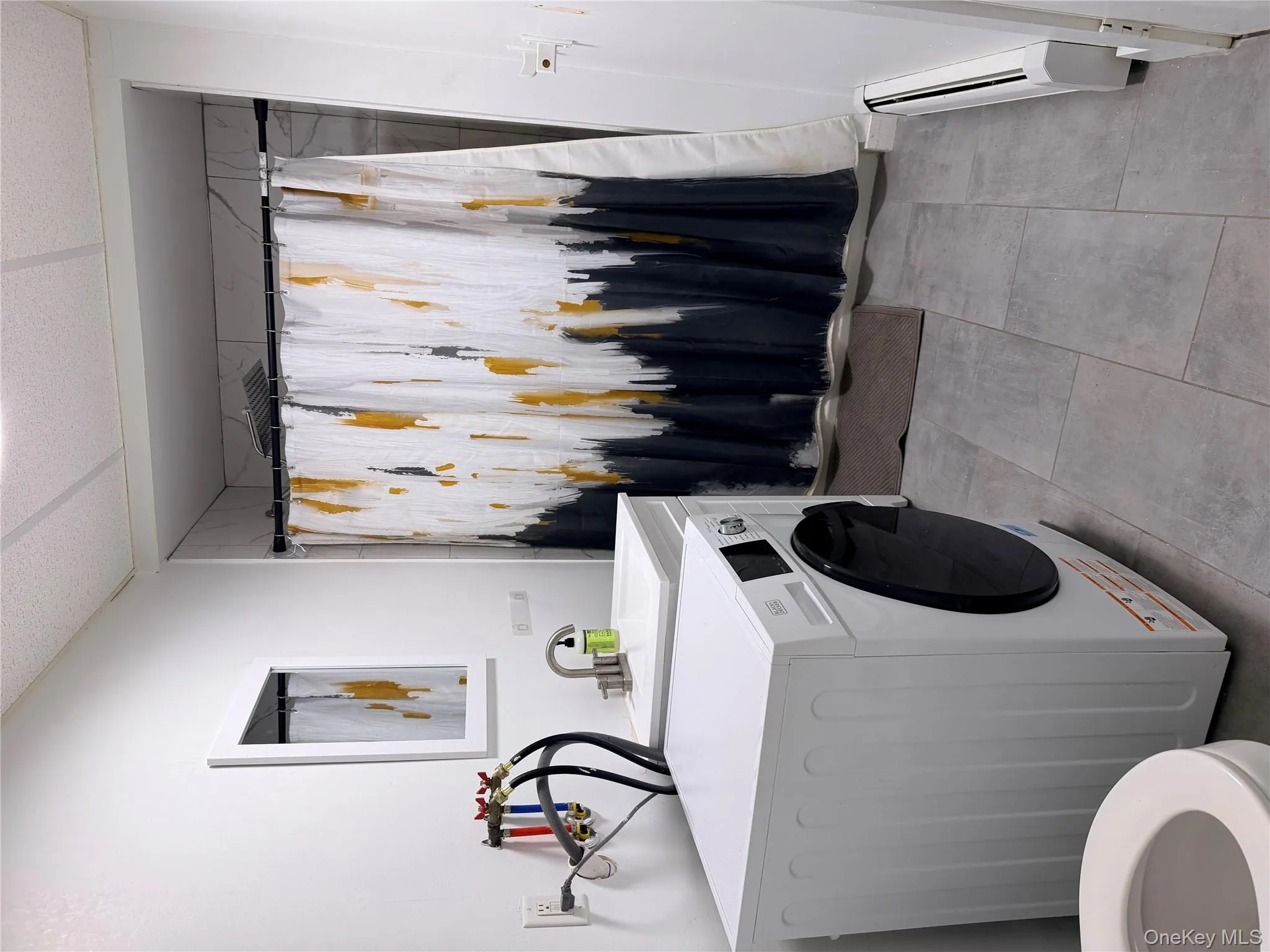 Bathroom with washer / clothes dryer, a stall shower, a baseboard radiator, and vanity Bathroom with washer / clothes dryer, a stall shower, a baseboard radiator, and vanity