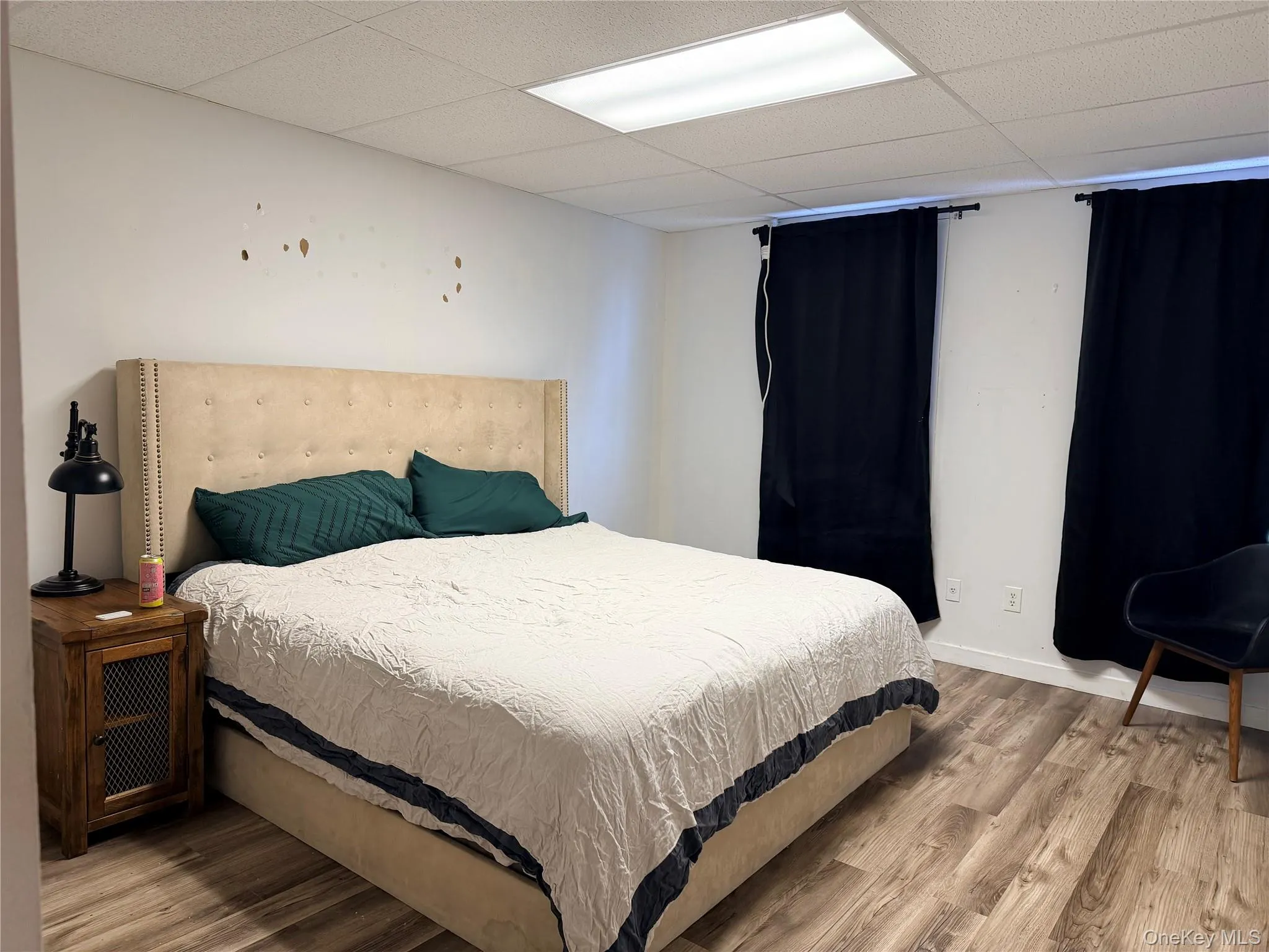 Bedroom with light wood finished floors and a drop ceiling Bedroom with light wood finished floors and a drop ceiling