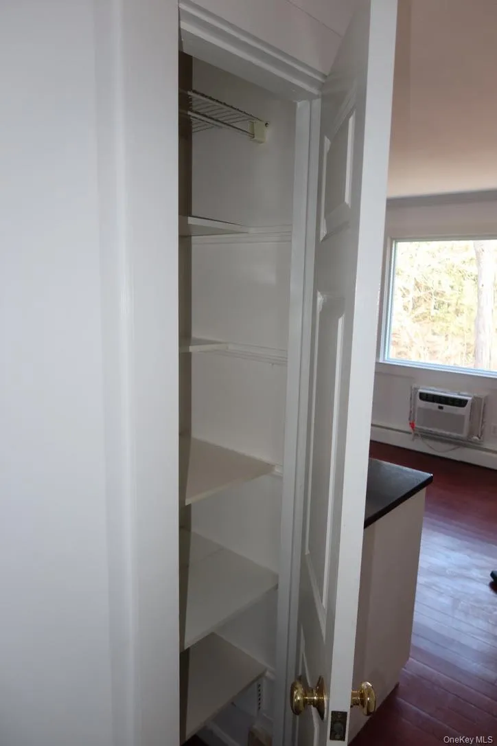Closet featuring a baseboard heating unit and a wall mounted air conditioner Closet featuring a baseboard heating unit and a wall mounted air conditioner