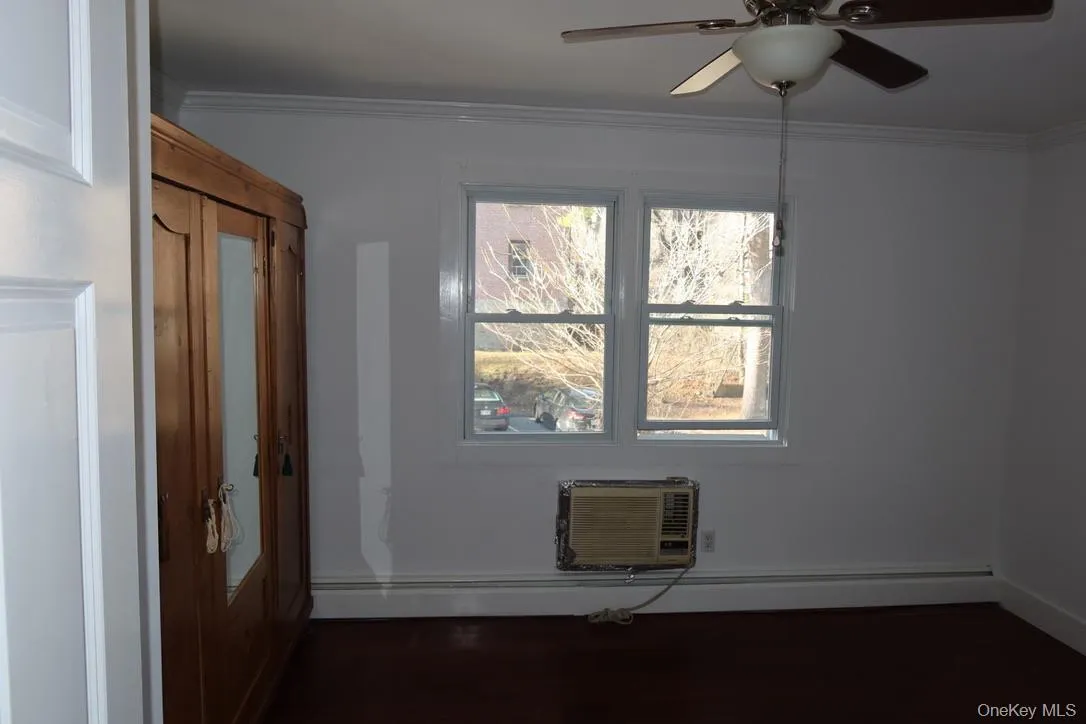 Spare room with crown molding, a ceiling fan, a baseboard heating unit, and a wall mounted air conditioner Spare room with crown molding, a ceiling fan, a baseboard heating unit, and a wall mounted air conditioner