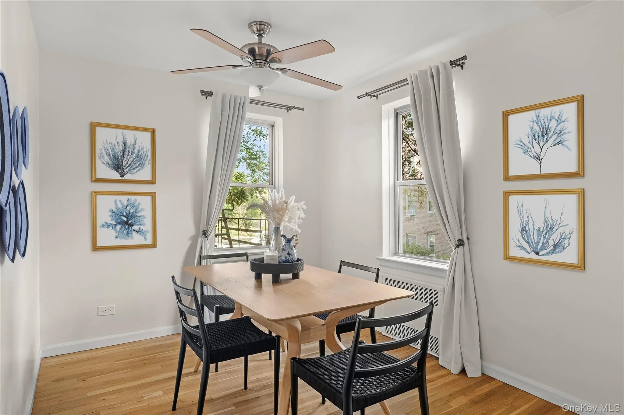 Dining room featuring light wood-style flooring, radiator heating unit, and ceiling fan Dining room featuring light wood-style flooring, radiator heating unit, and ceiling fan
