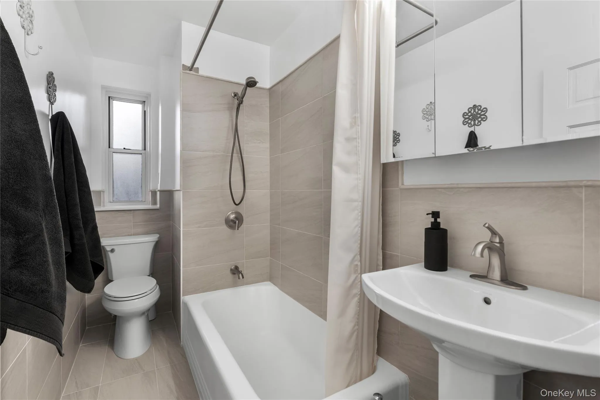 Full bath with tile walls and shower / bathtub combination with curtain Full bath with tile walls and shower / bathtub combination with curtain
