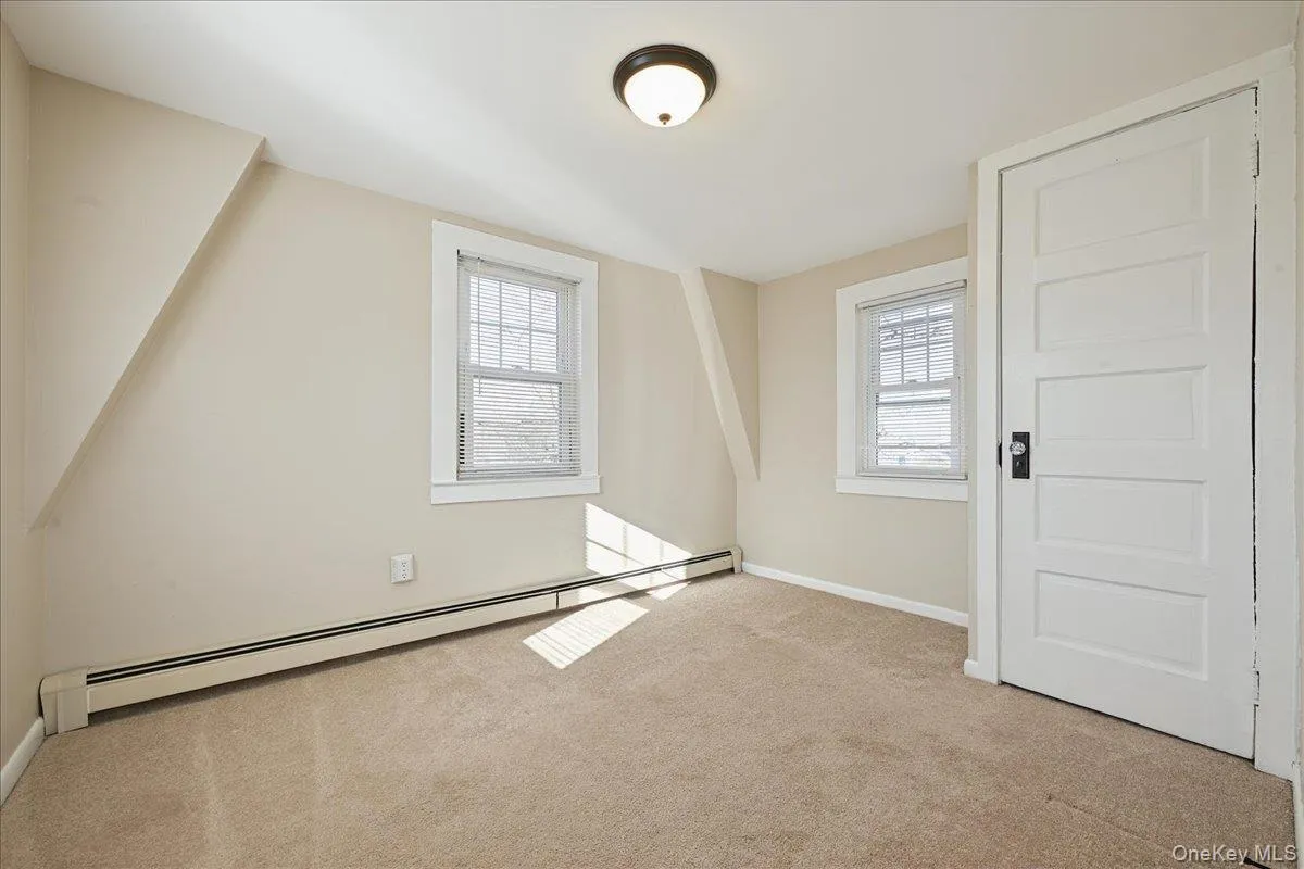 Additional living space with a baseboard heating unit and carpet Additional living space with a baseboard heating unit and carpet