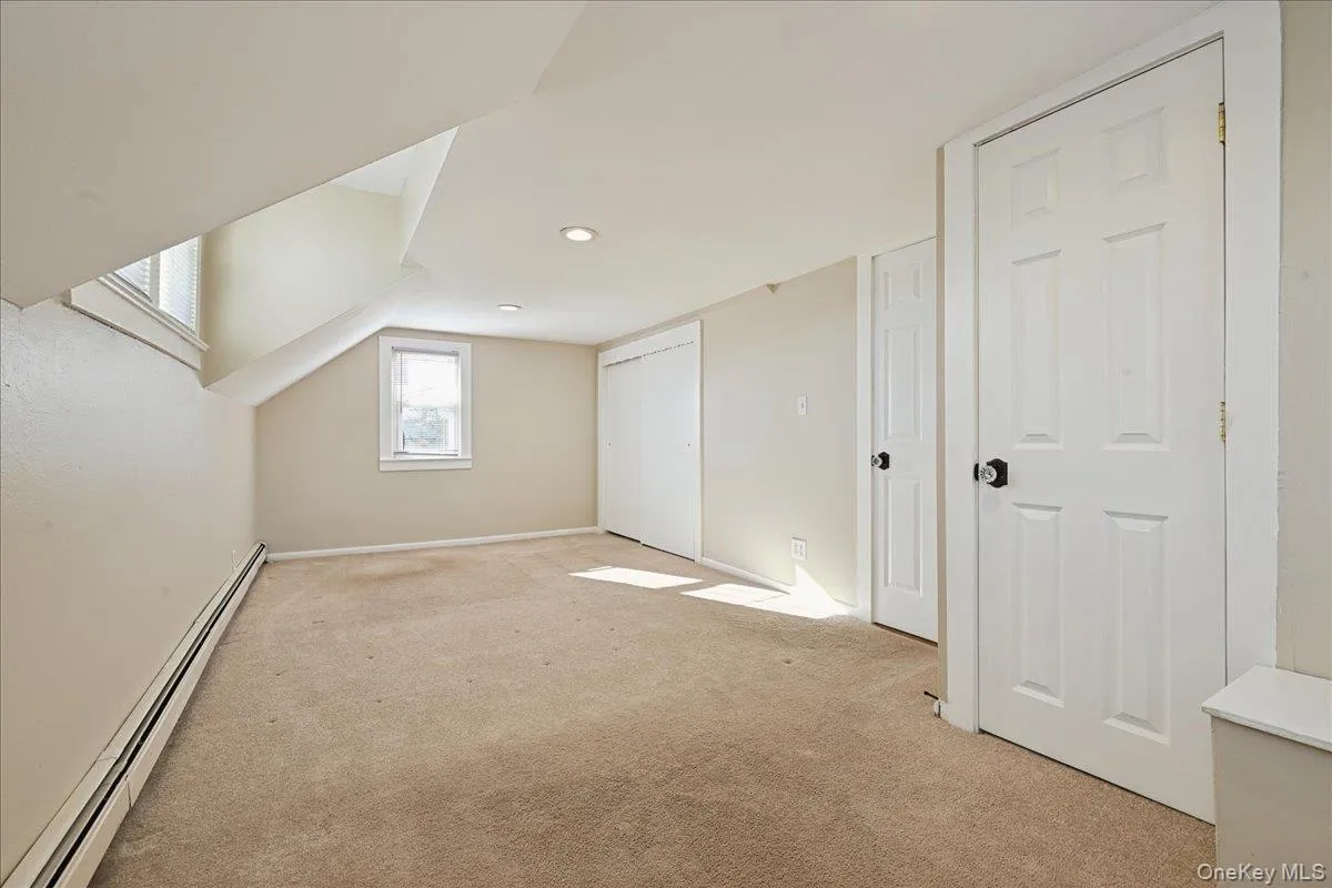 Bonus room featuring baseboard heating and carpet Bonus room featuring baseboard heating and carpet