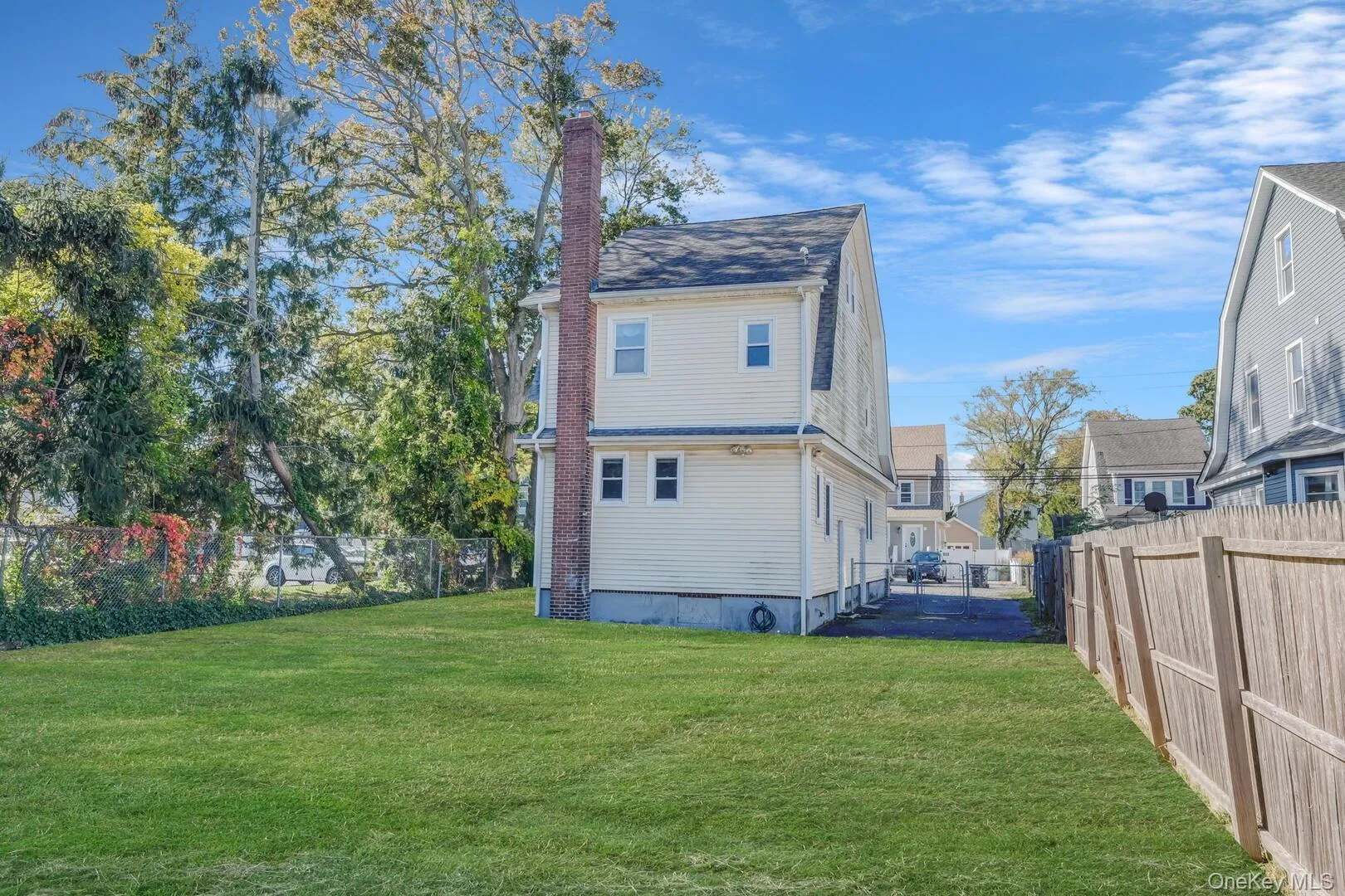 Rear view of house with a fenced backyard and a chimney Rear view of house with a fenced backyard and a chimney