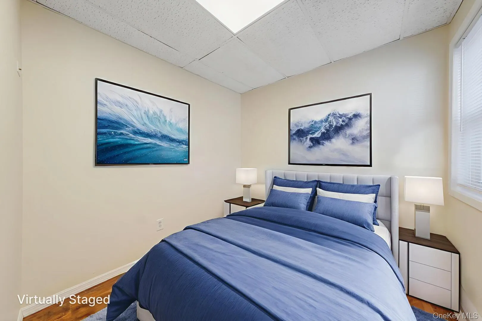Bedroom with a drop ceiling and wood finished floors Bedroom with a drop ceiling and wood finished floors