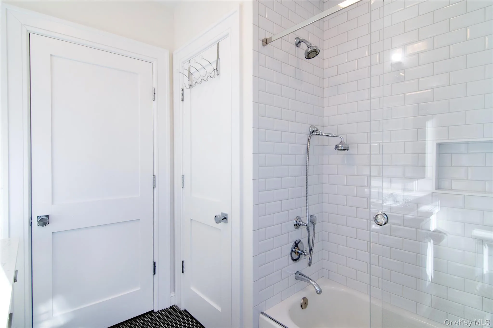 The hall bathroom includes a tub and shower with timeless white tile The hall bathroom includes a tub and shower with timeless white tile