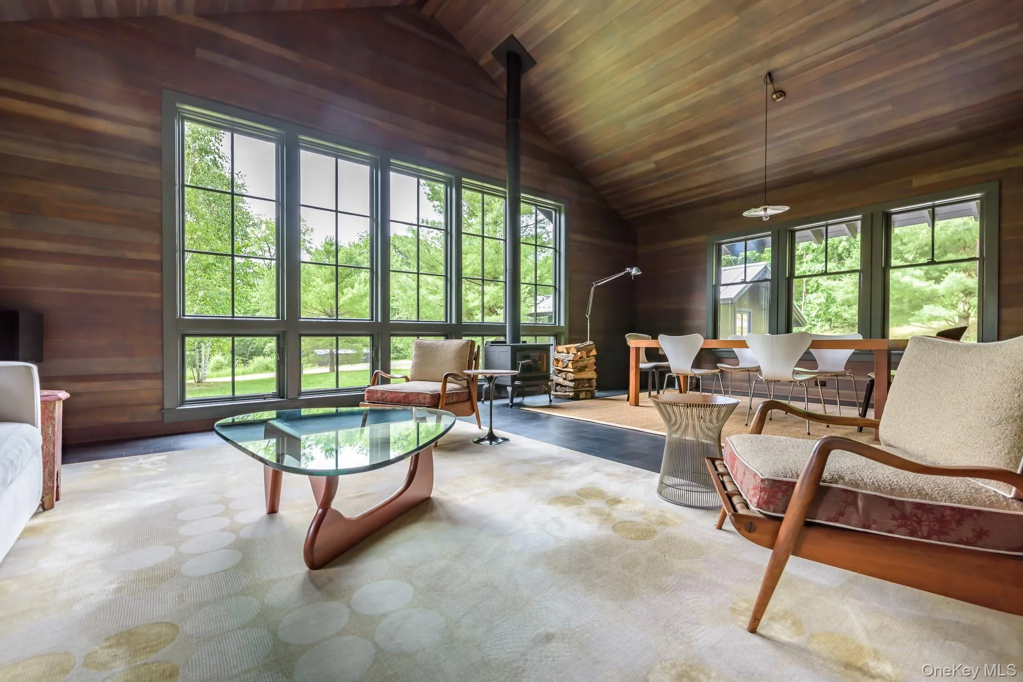 Living area featuring wooden walls, wooden ceiling, and vaulted ceiling Living area featuring wooden walls, wooden ceiling, and vaulted ceiling
