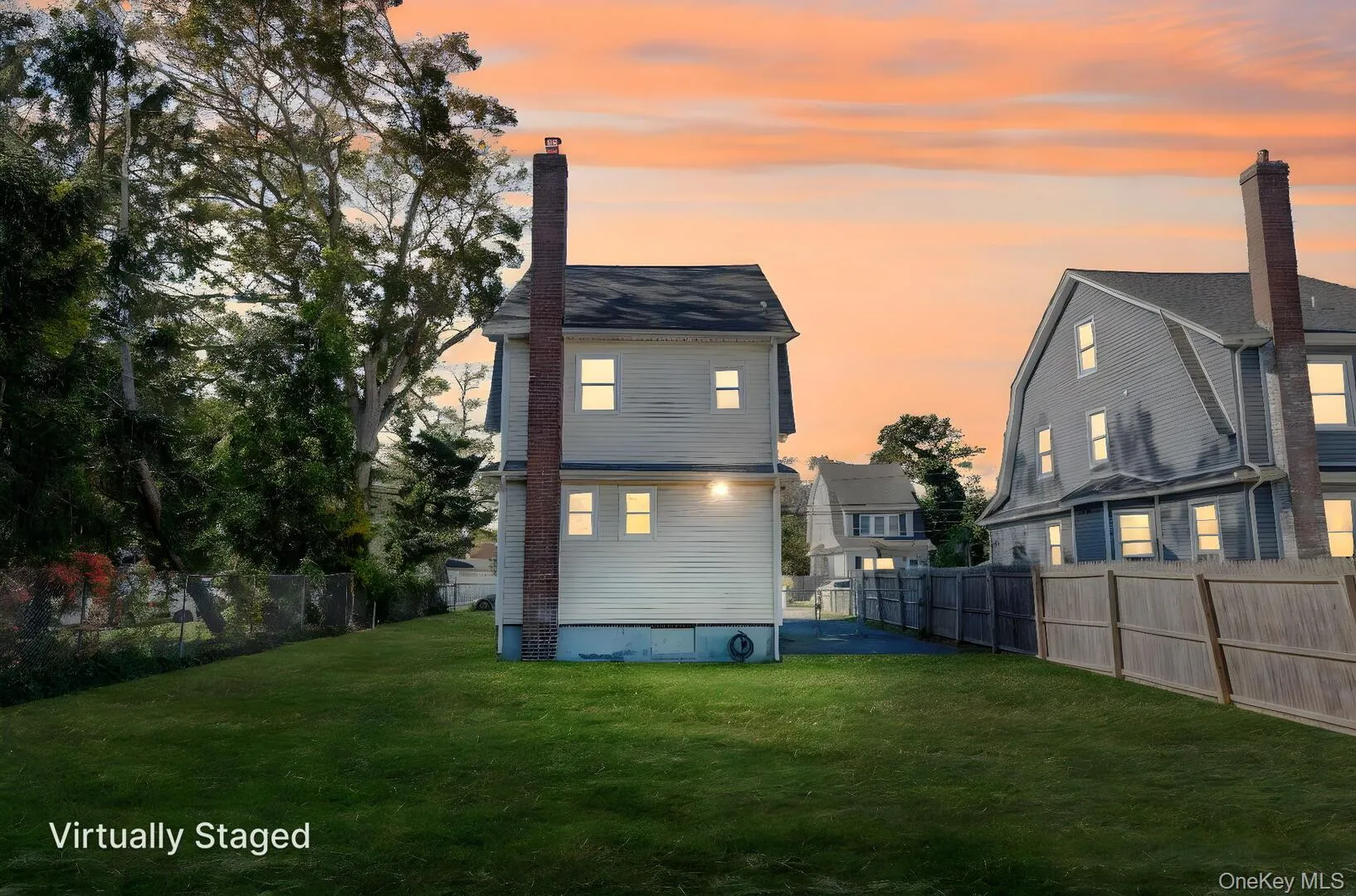 Back of house with a fenced backyard and a chimney Back of house with a fenced backyard and a chimney