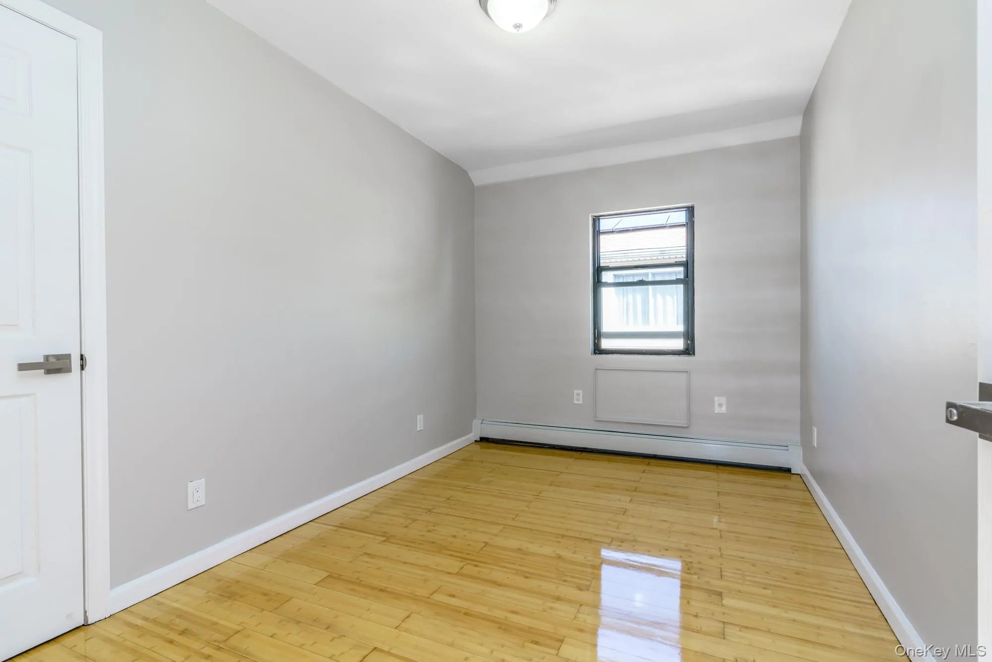 Spare room with baseboard heating and light wood-type flooring Spare room with baseboard heating and light wood-type flooring