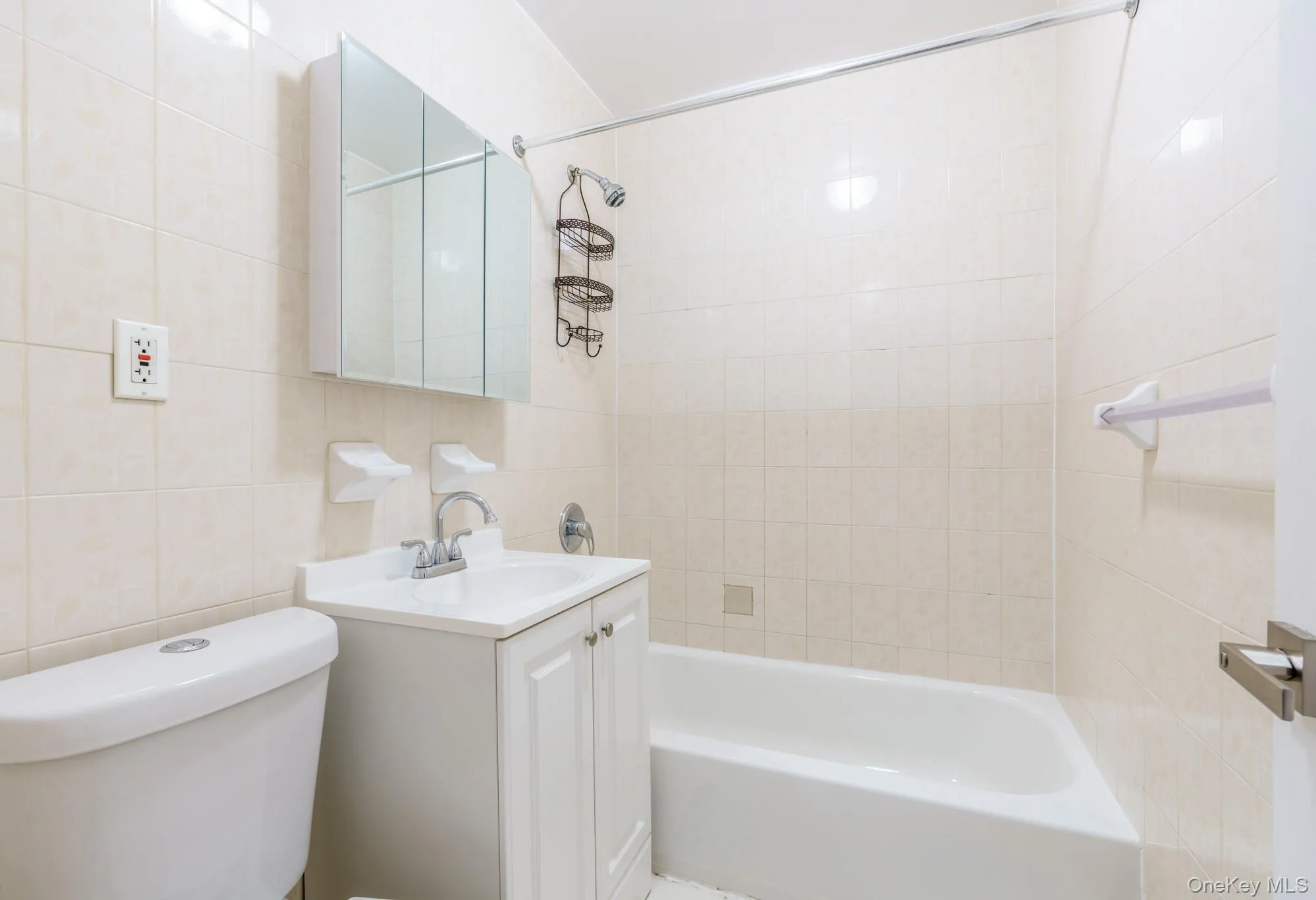 Bathroom with vanity, bathtub / shower combination, and tile walls Bathroom with vanity, bathtub / shower combination, and tile walls