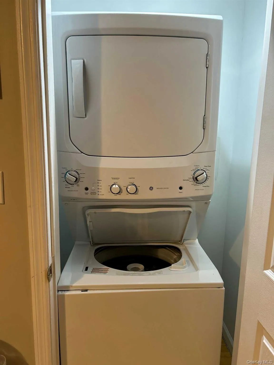 Washroom with stacked washer / drying machine Washroom with stacked washer / drying machine