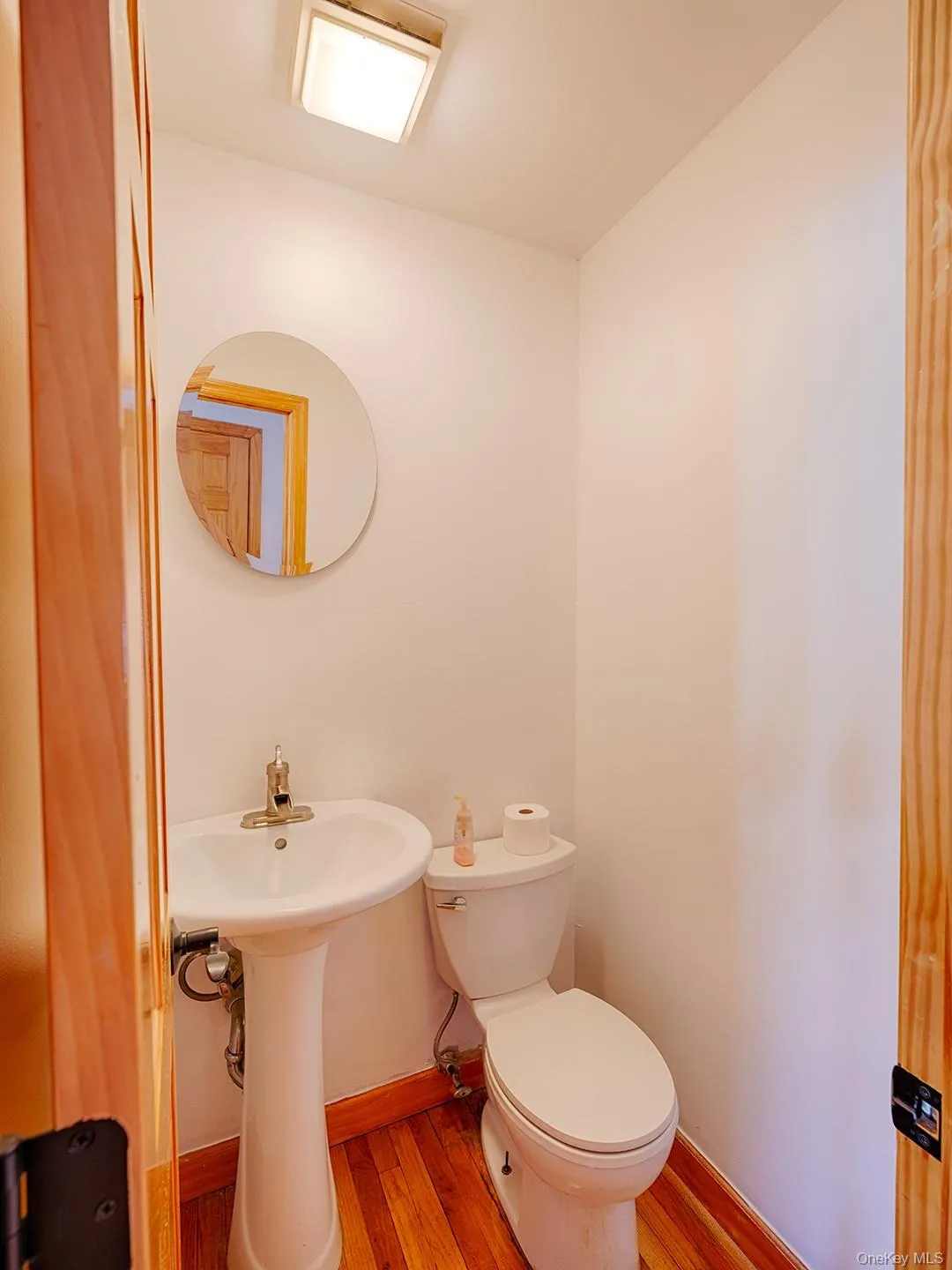 Bathroom featuring wood finished floors and toilet Bathroom featuring wood finished floors and toilet