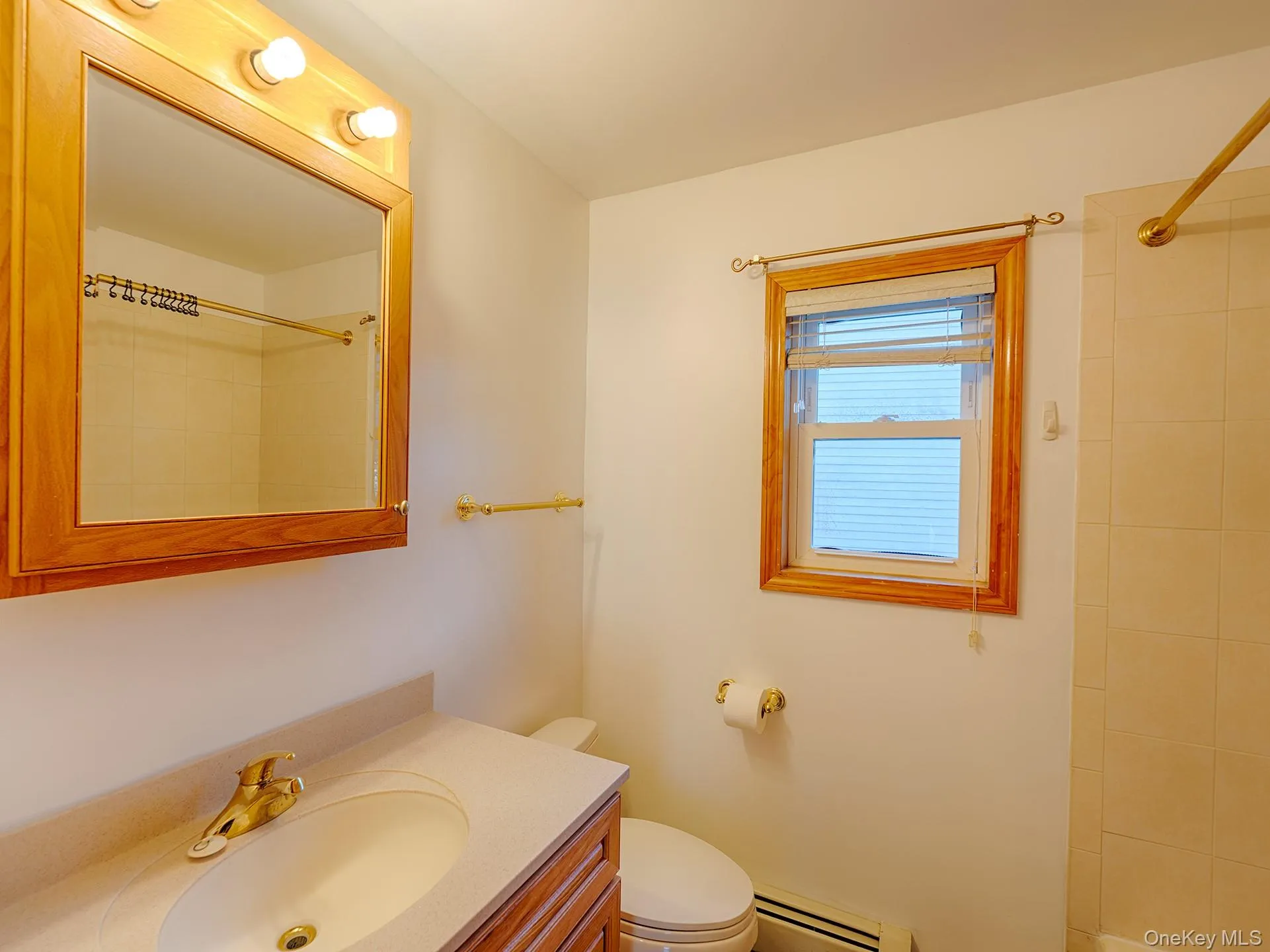 Full bath with vanity, a baseboard heating unit, and a shower Full bath with vanity, a baseboard heating unit, and a shower