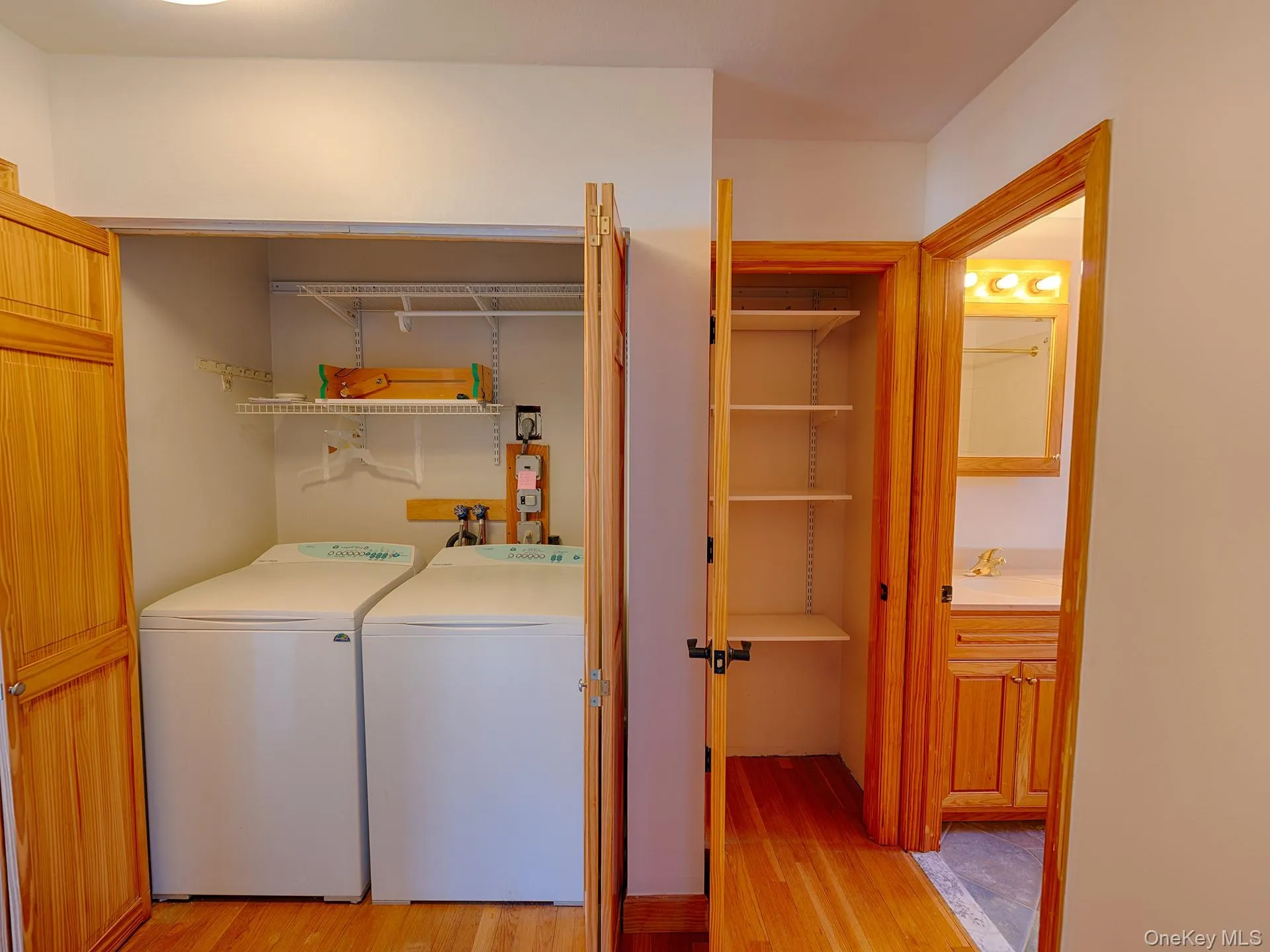Washroom featuring light wood finished floors and separate washer and dryer Washroom featuring light wood finished floors and separate washer and dryer
