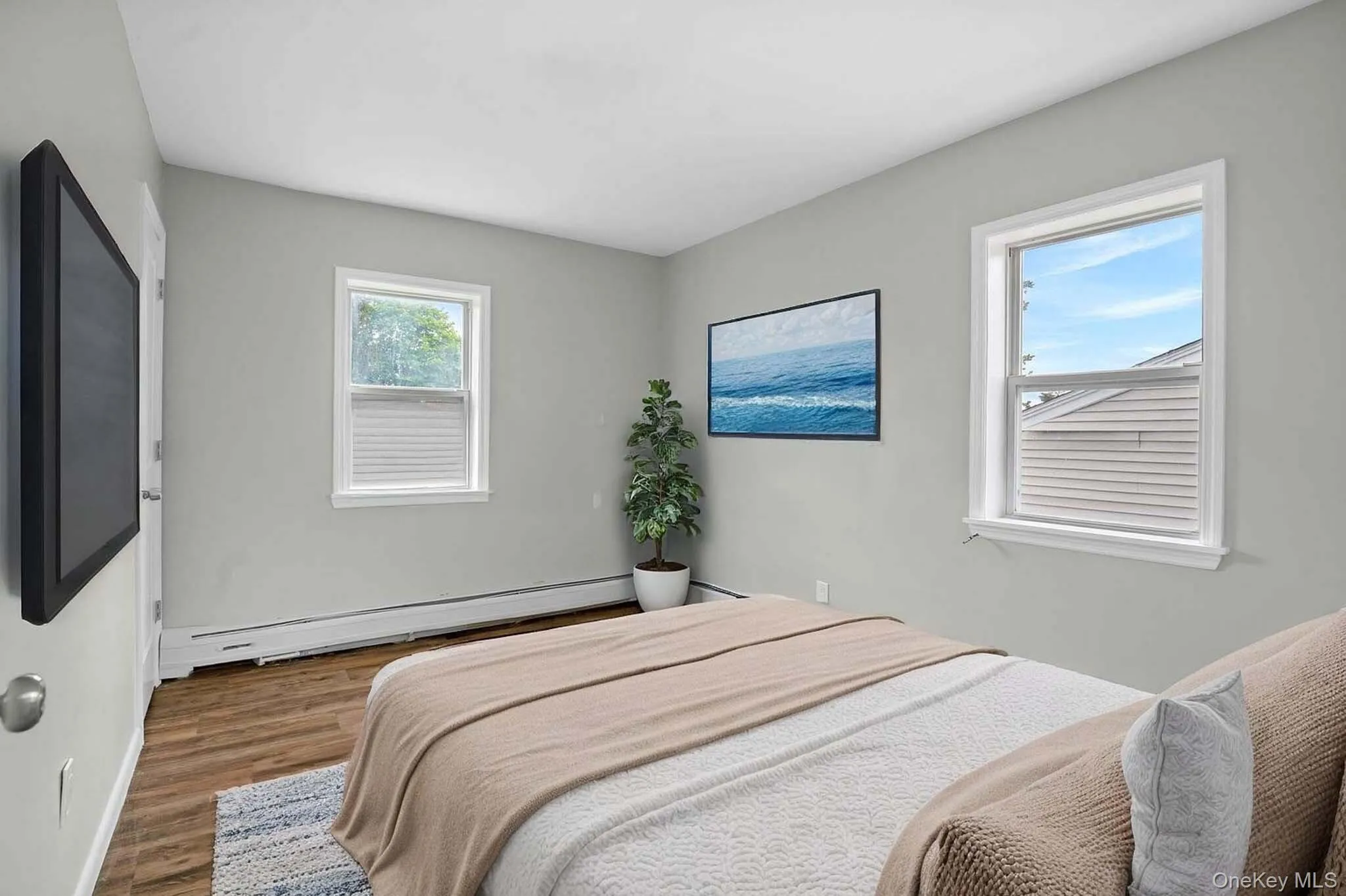 Bedroom with a baseboard heating unit, wood finished floors, and baseboards. Virtually Staged Bedroom with a baseboard heating unit, wood finished floors, and baseboards. Virtually Staged