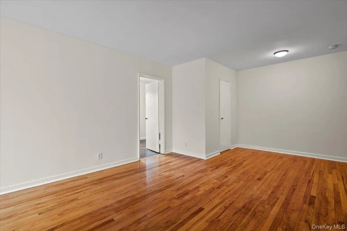 Spare room featuring light wood-type flooring and baseboards Spare room featuring light wood-type flooring and baseboards