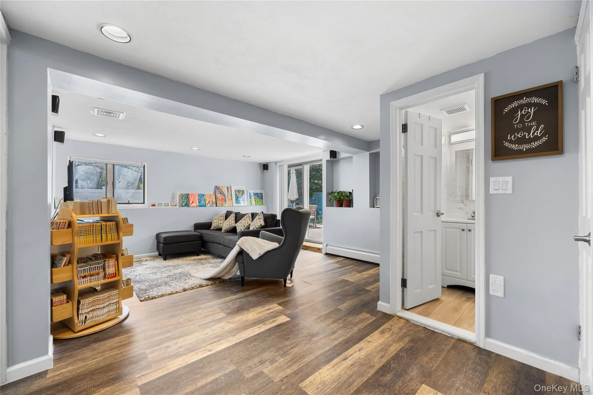 Living room featuring wood finished floors, baseboard heating, and recessed lighting Living room featuring wood finished floors, baseboard heating, and recessed lighting