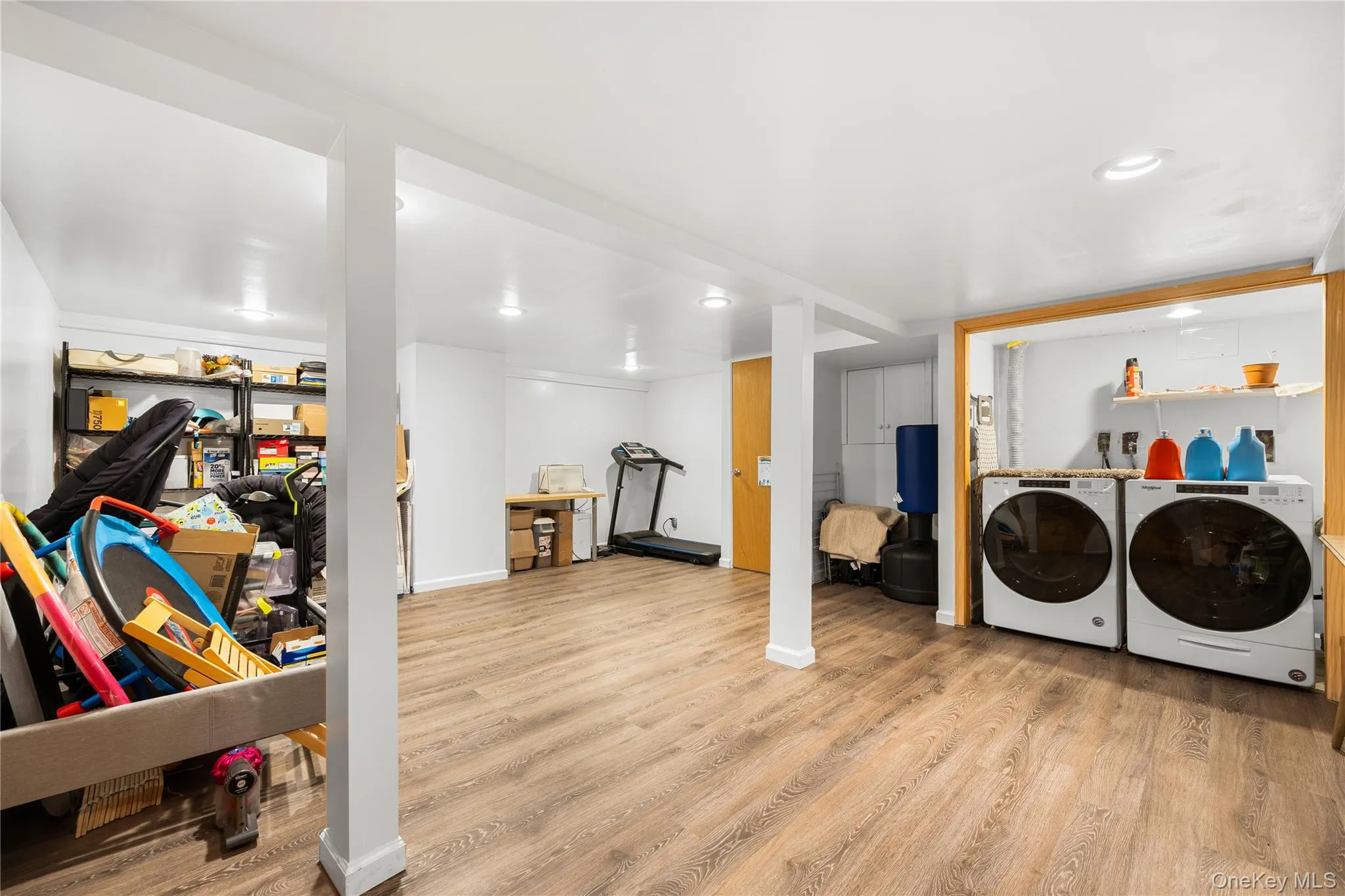 Washroom featuring independent washer and dryer and light wood finished floors Washroom featuring independent washer and dryer and light wood finished floors