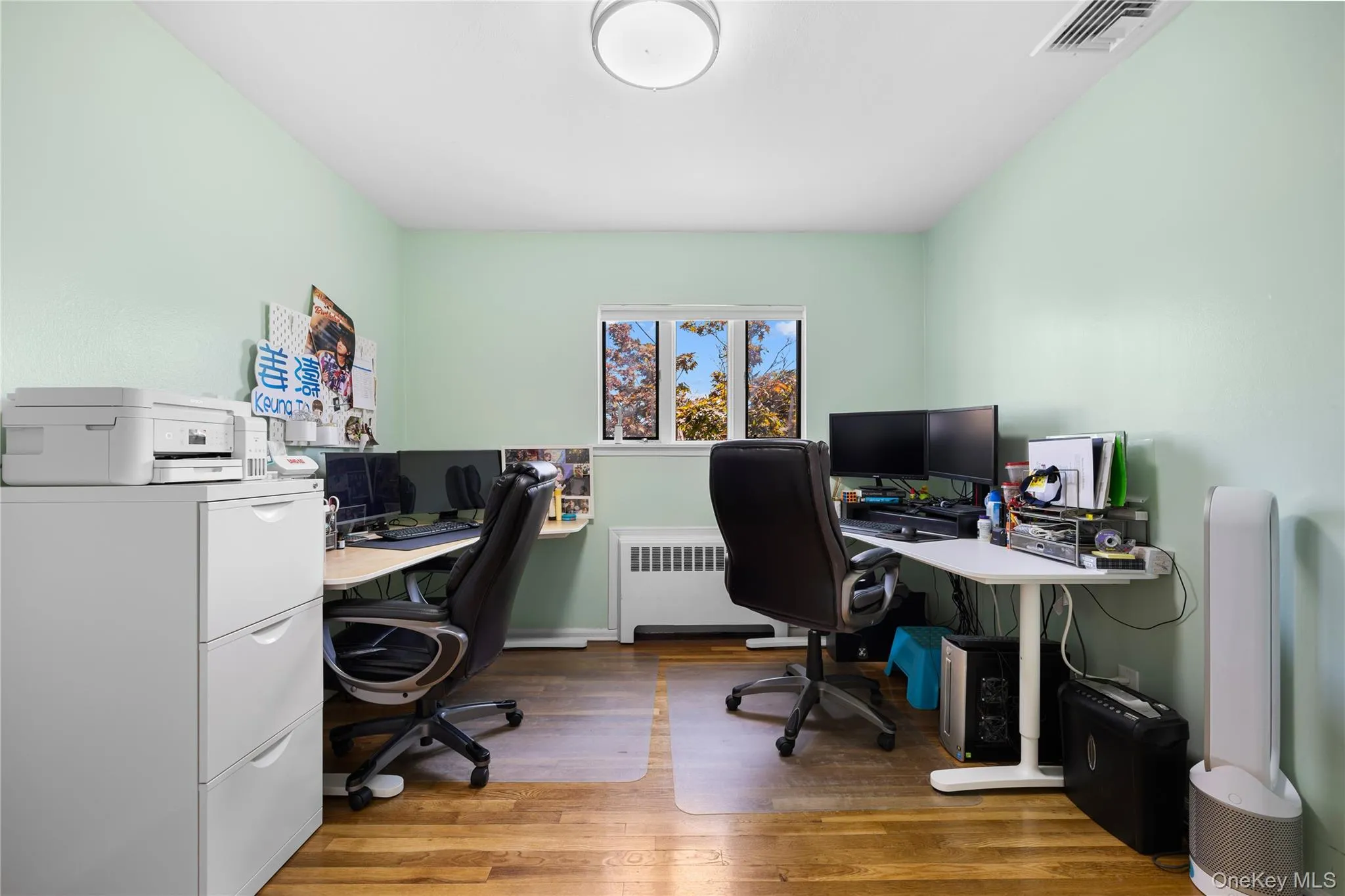 Office area featuring dark wood-type flooring and radiator heating unit Office area featuring dark wood-type flooring and radiator heating unit