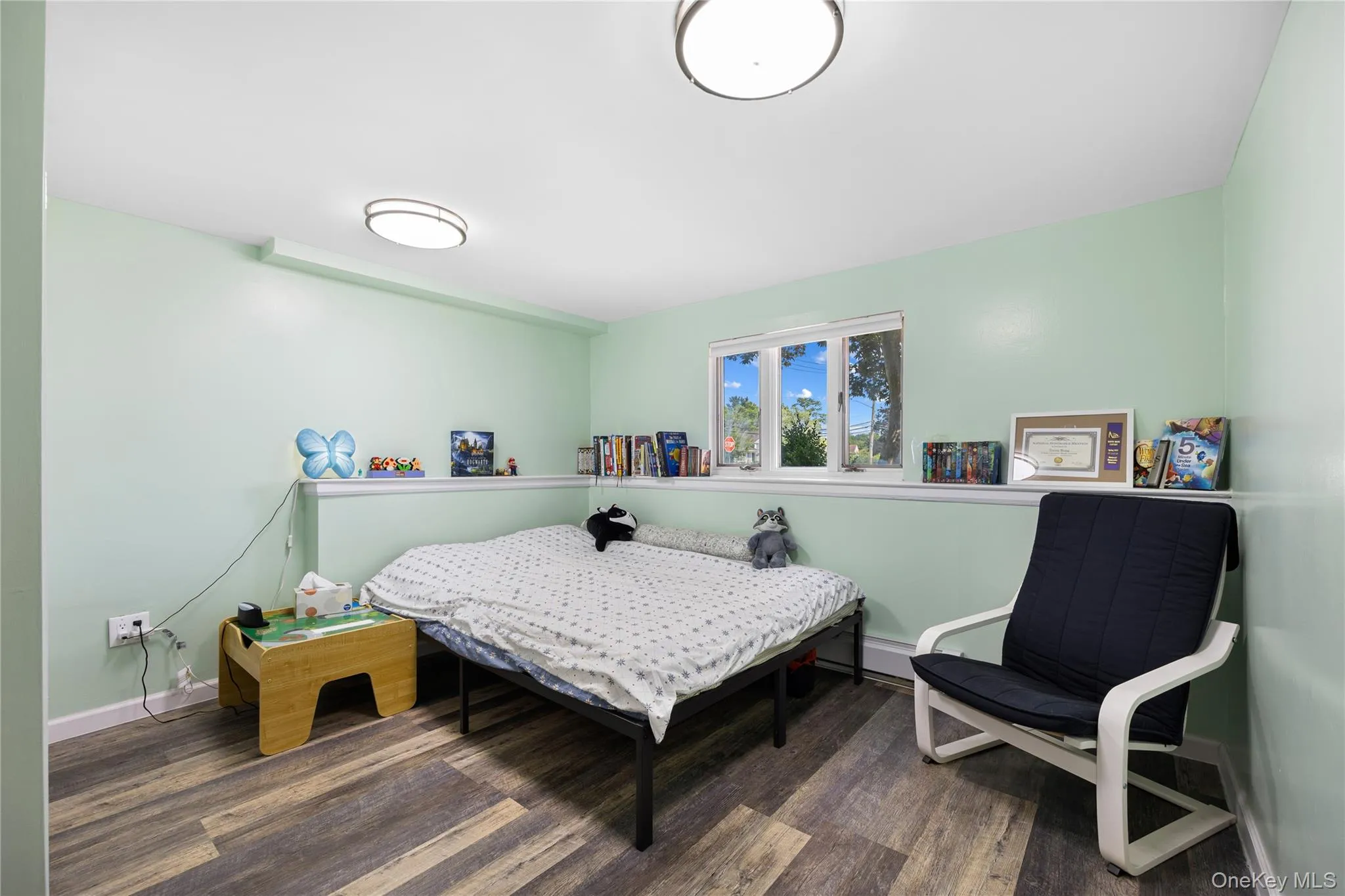 Bedroom with dark wood-style flooring and baseboard heating Bedroom with dark wood-style flooring and baseboard heating