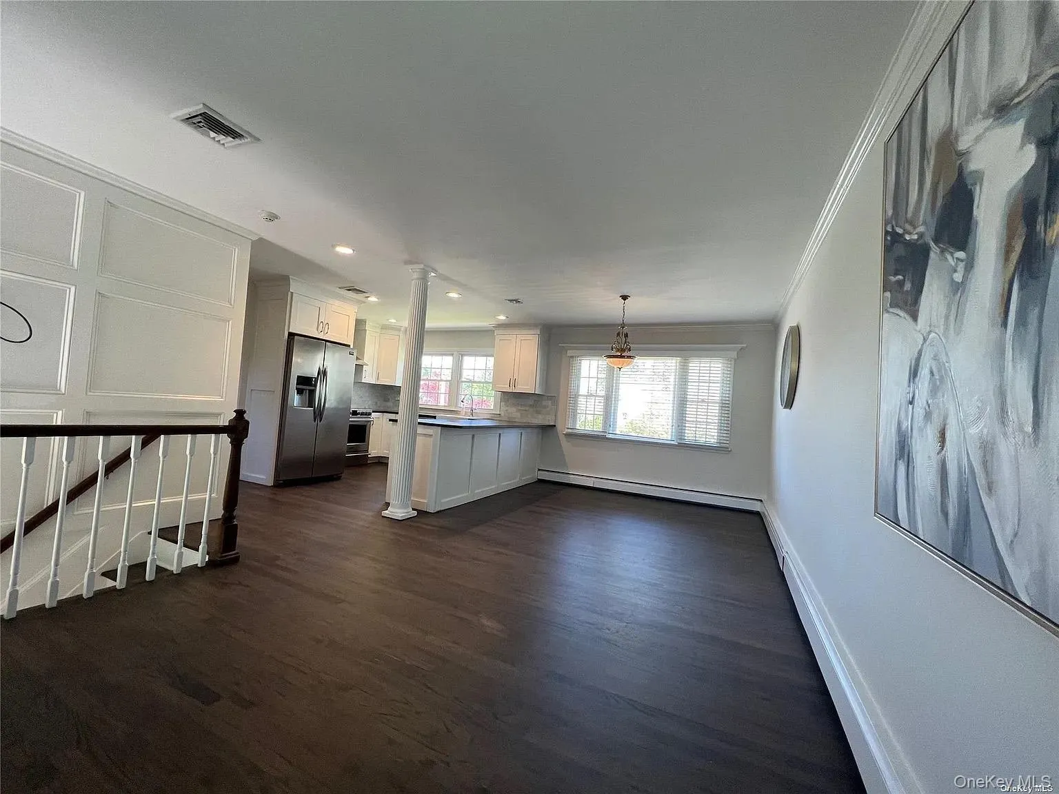 Unfurnished living room with dark wood-type flooring, recessed lighting, a baseboard radiator, ornamental molding, and baseboard heating Unfurnished living room with dark wood-type flooring, recessed lighting, a baseboard radiator, ornamental molding, and baseboard heating