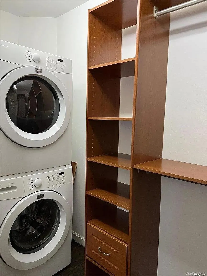 Washroom featuring stacked washer / drying machine Washroom featuring stacked washer / drying machine