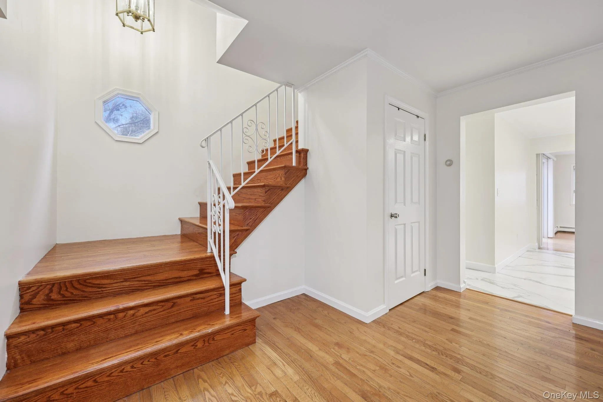 Stairs featuring hardwood / wood-style flooring and crown molding Stairs featuring hardwood / wood-style flooring and crown molding
