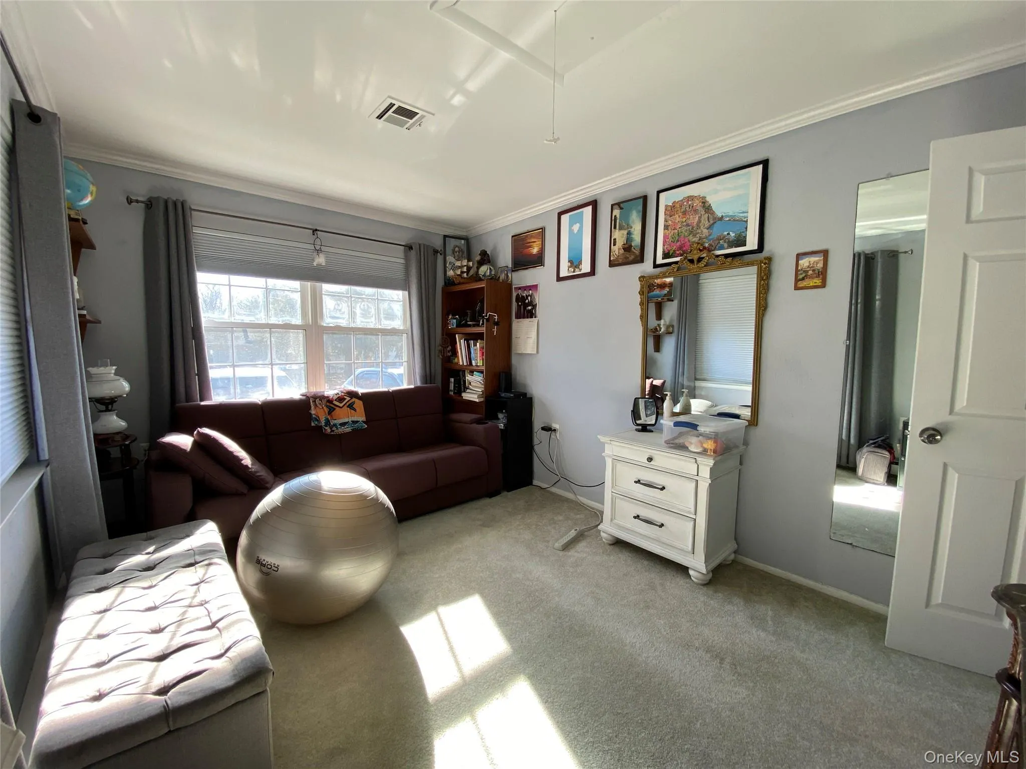 Bedroom with light colored carpet, attic access, and ornamental molding Bedroom with light colored carpet, attic access, and ornamental molding