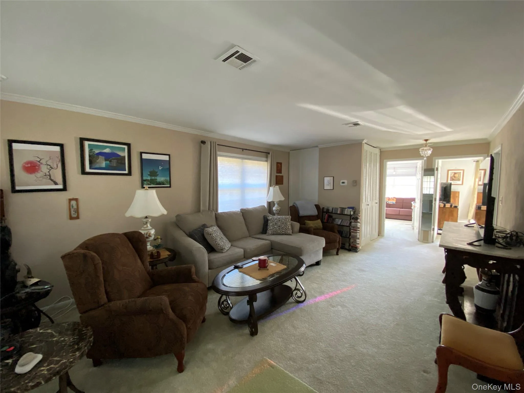 Carpeted living room with healthy amount of natural light and crown molding Carpeted living room with healthy amount of natural light and crown molding