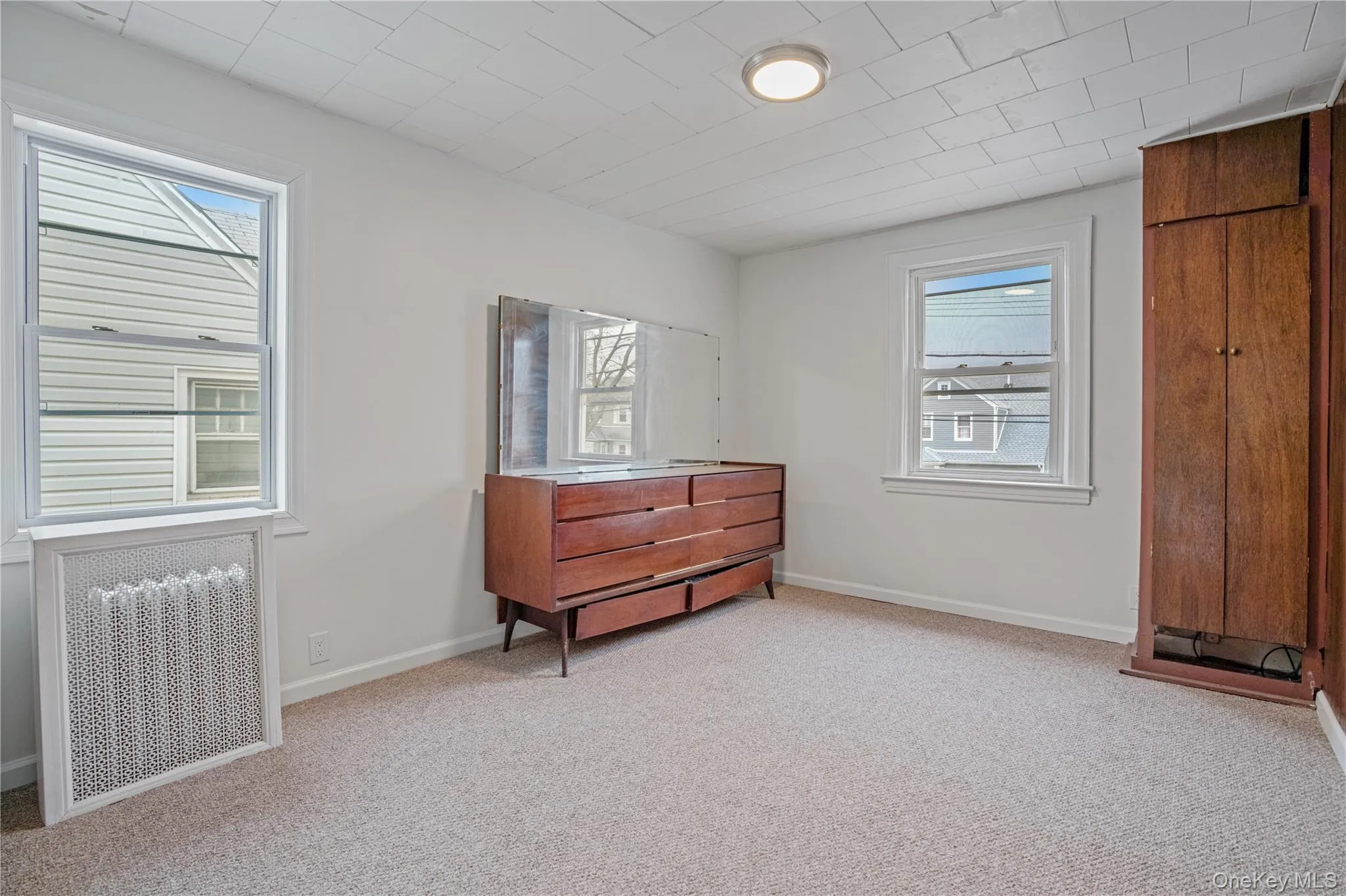 Living area featuring light carpet and radiator Living area featuring light carpet and radiator