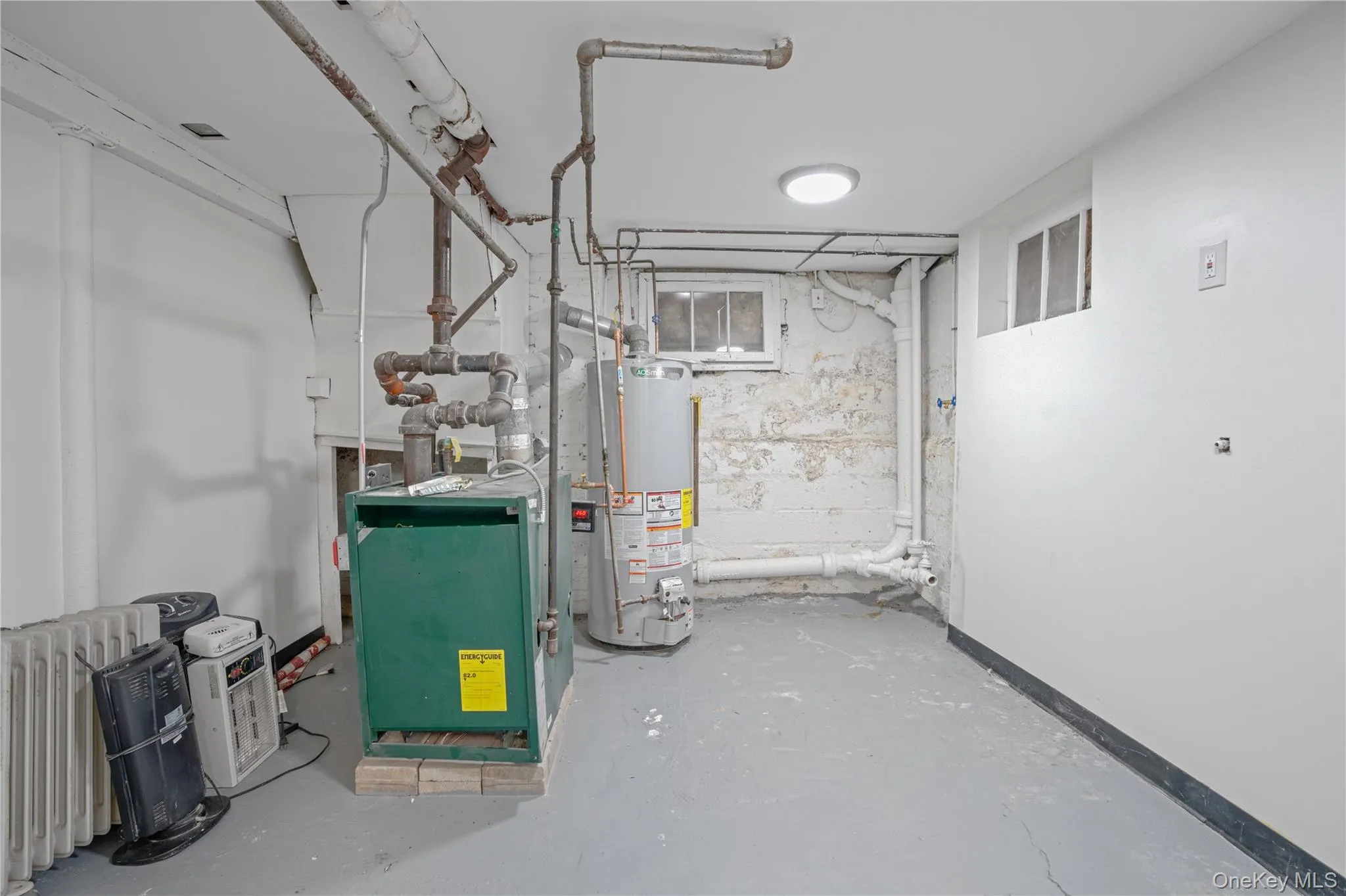 Utility room with gas water heater and a heating unit Utility room with gas water heater and a heating unit
