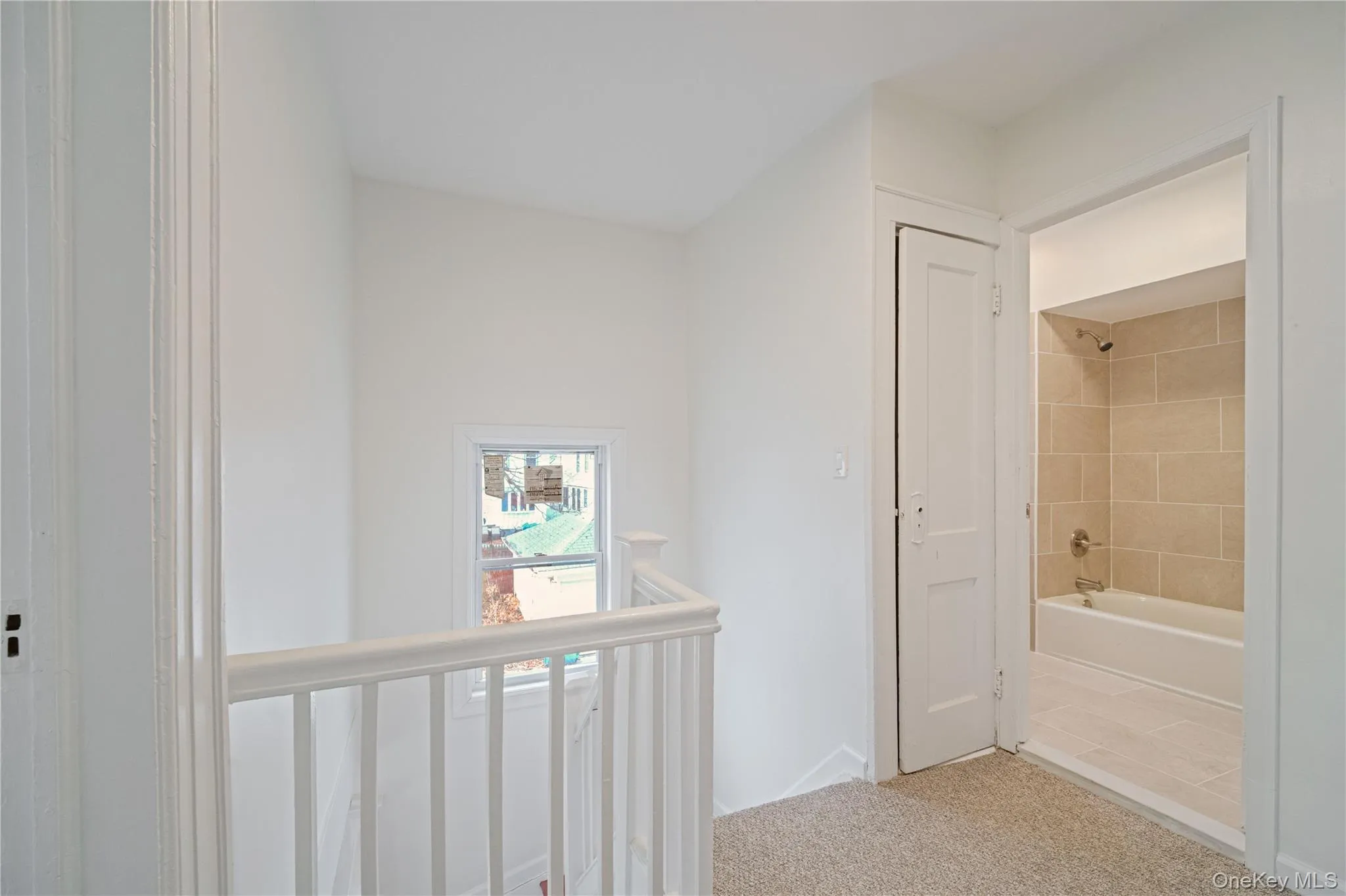 Hallway featuring light carpet and baseboards Hallway featuring light carpet and baseboards
