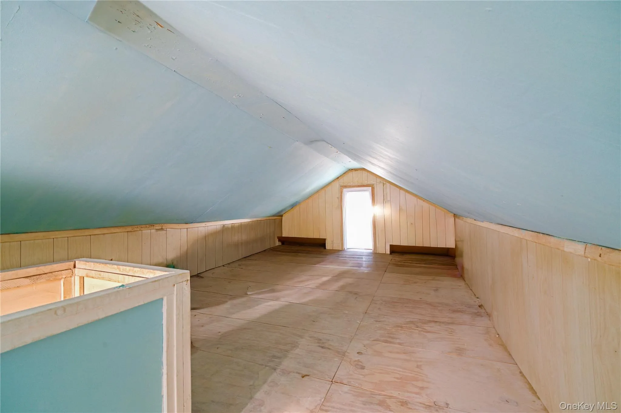 Bonus room featuring vaulted ceiling and wooden walls Bonus room featuring vaulted ceiling and wooden walls