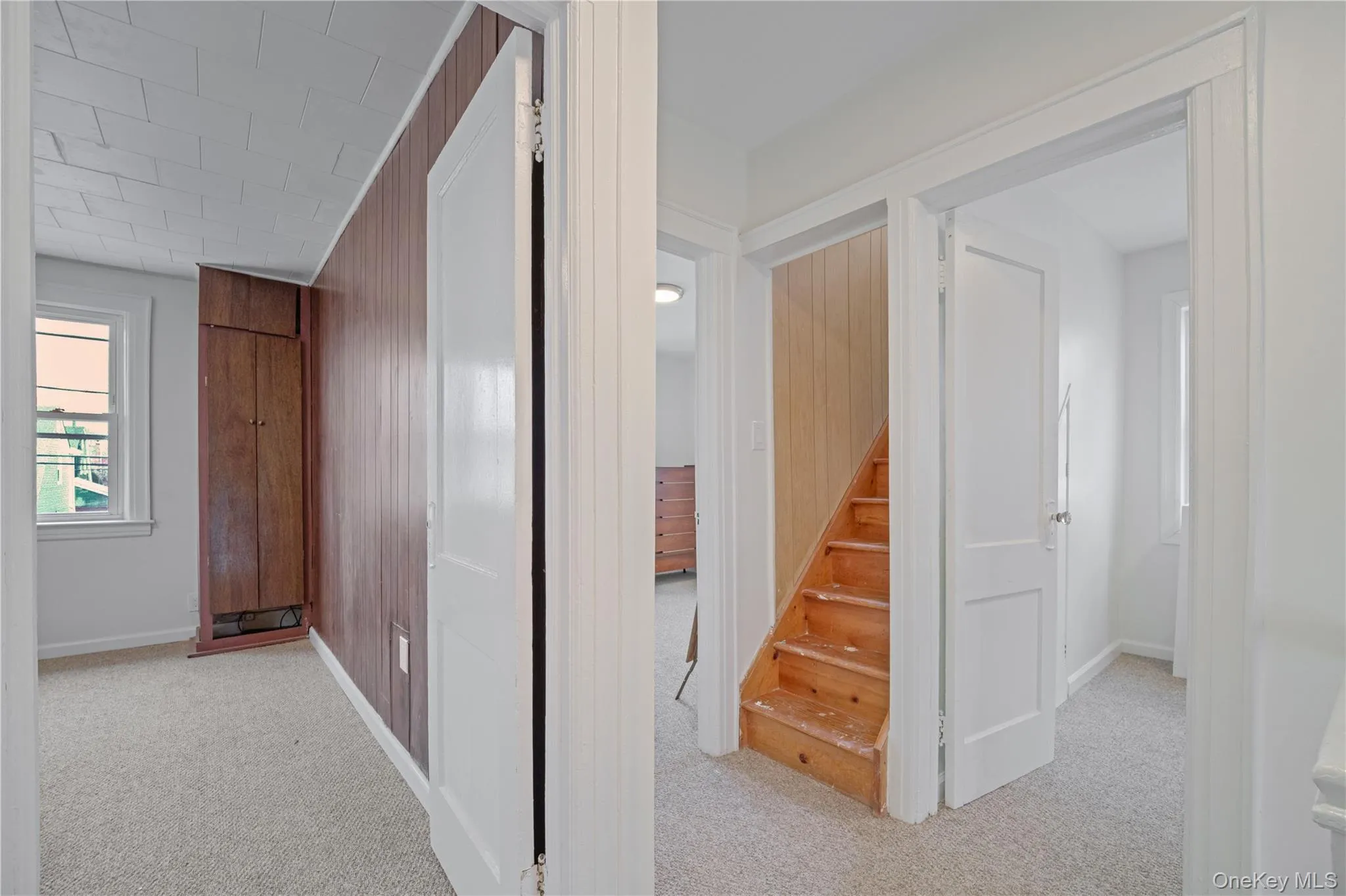 Hall featuring light colored carpet and stairway Hall featuring light colored carpet and stairway